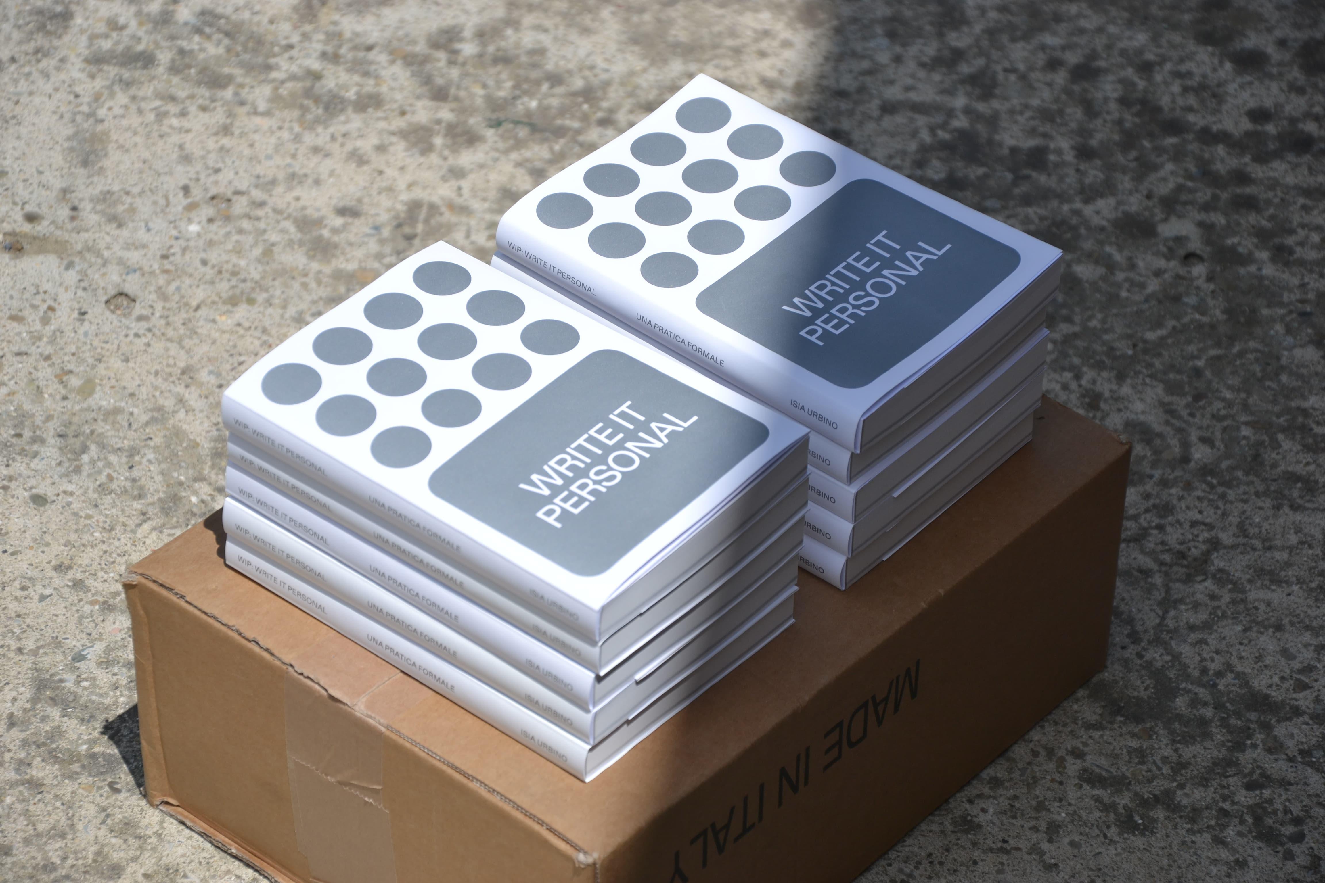 Stacks of Write It Personal books with grey circular covers.