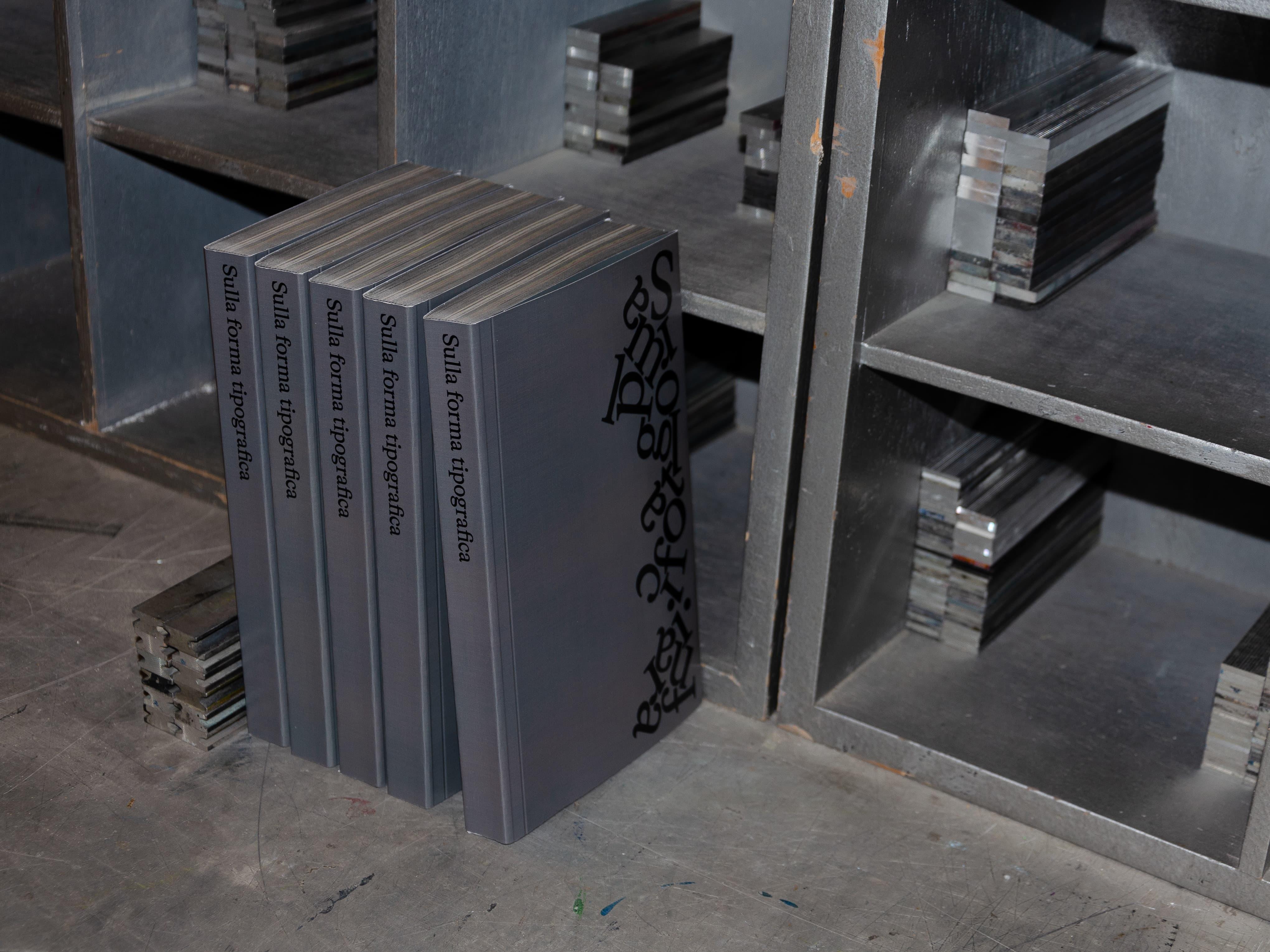 Grey Sulla forma tipografica books on metal shelves.