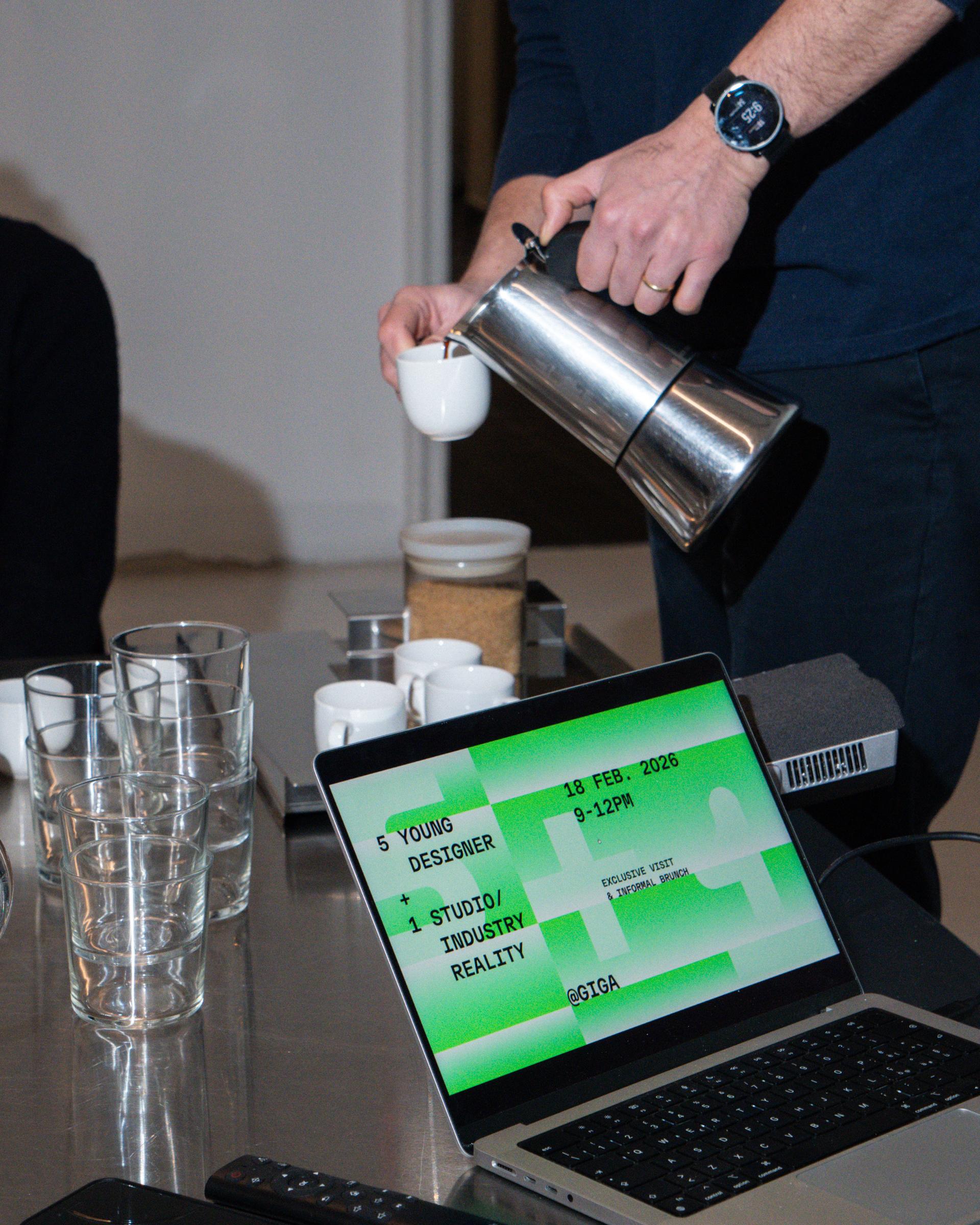 Coffee being poured beside a laptop displaying the 5+1 at Giga invitation.