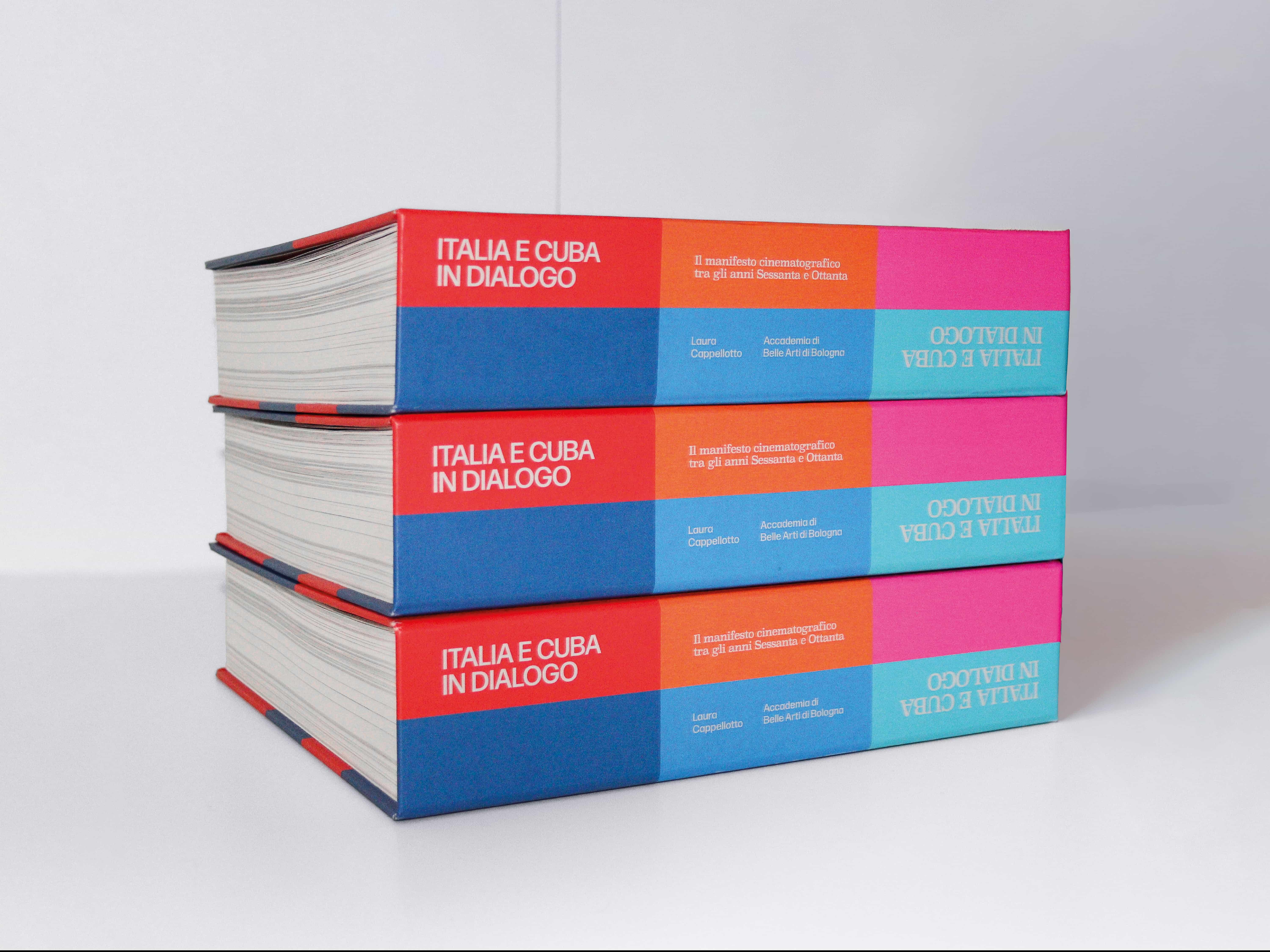 Three copies of Italia e Cuba in dialogo stacked, showing their colour-blocked spines and page edges.