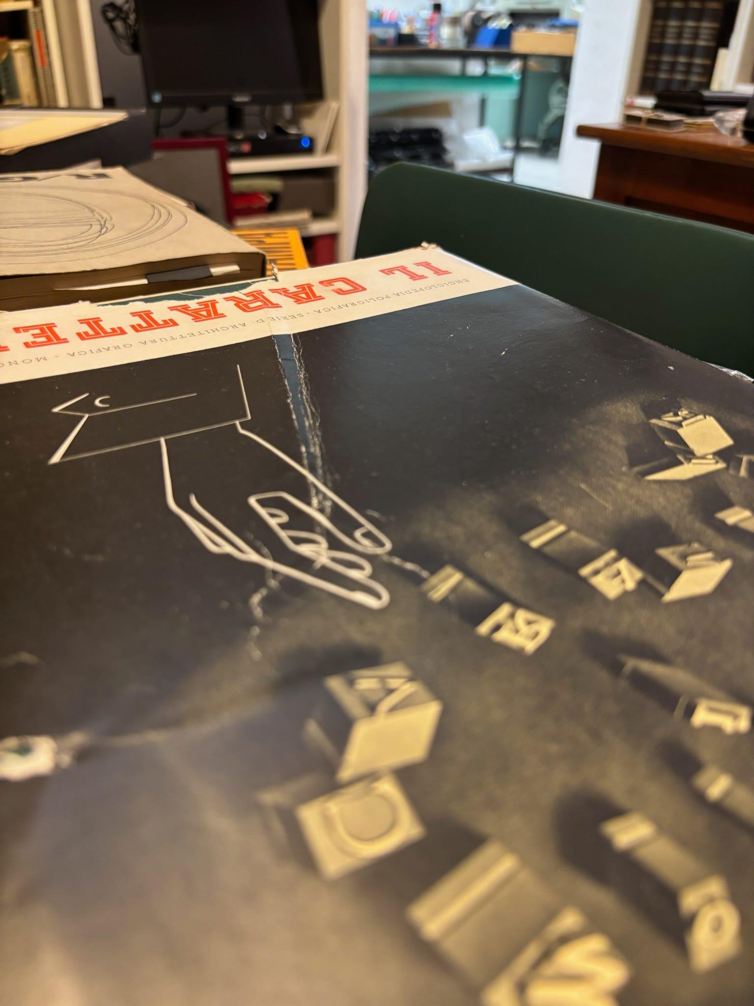 Close-up of an issue of "Il Carattere" with a geometric illustration and printed type.