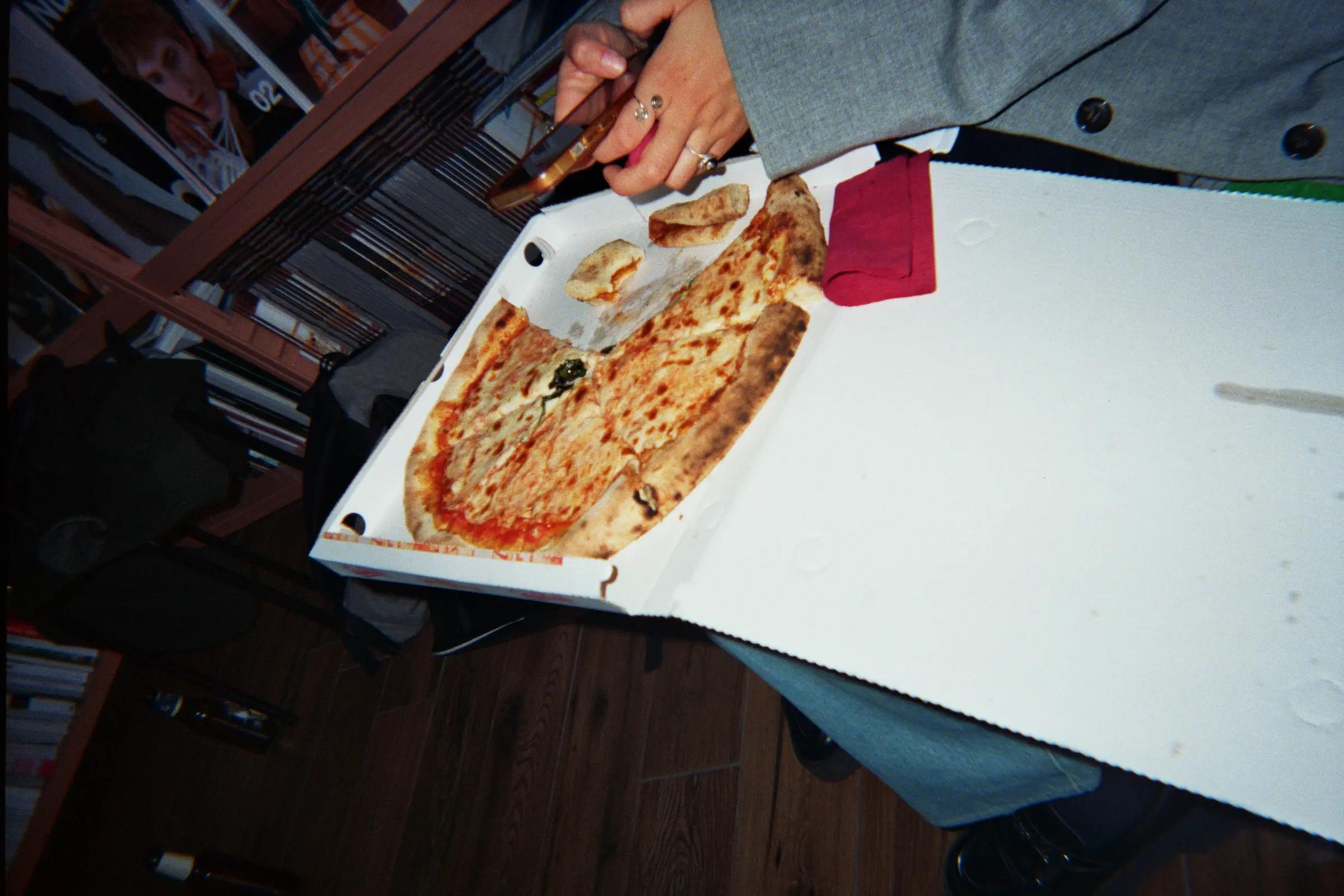 Pizza boxes and beer bottles beside a computer monitor at Frab's.
