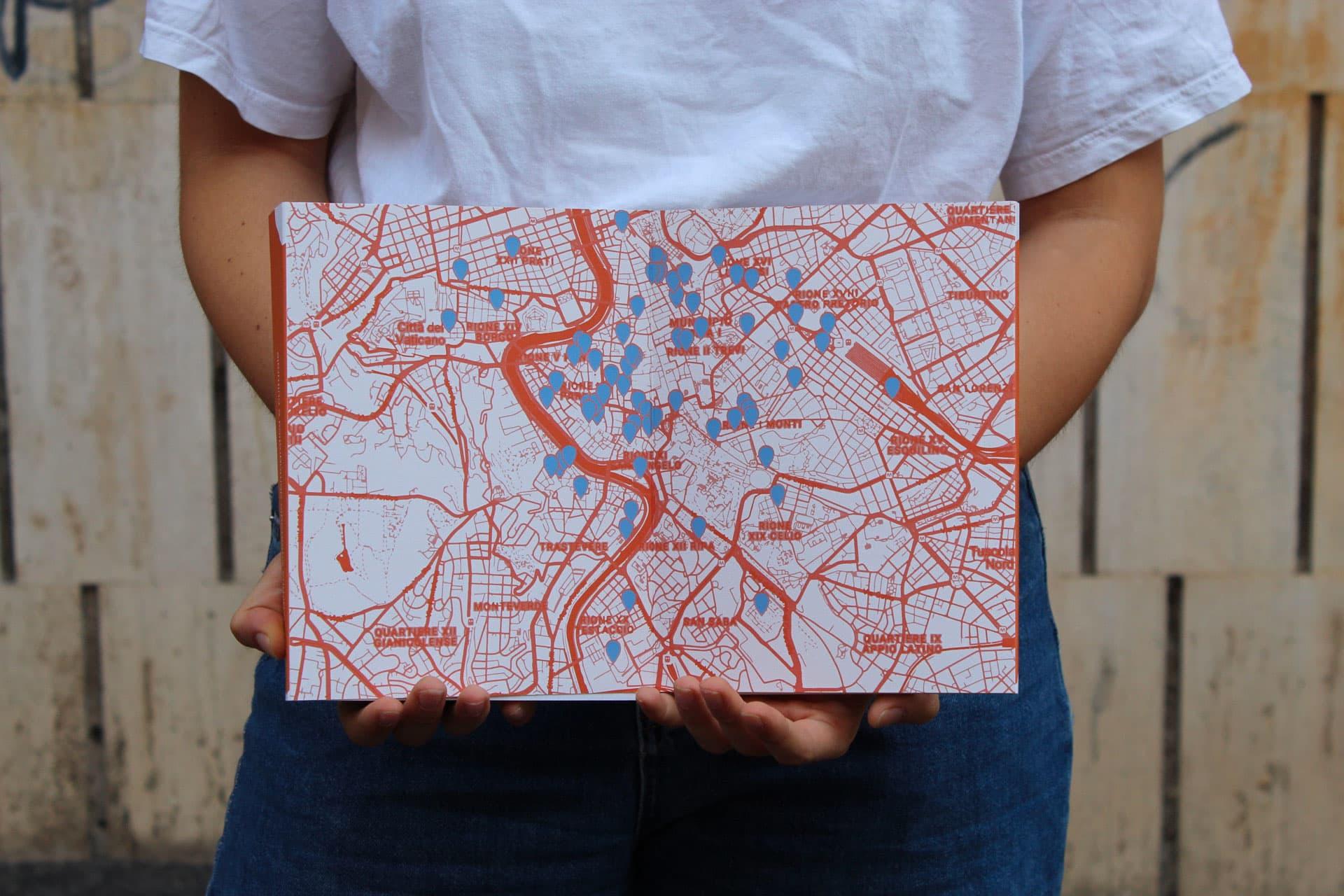 Person holding a white board printed with a red-and-blue map of Rome.