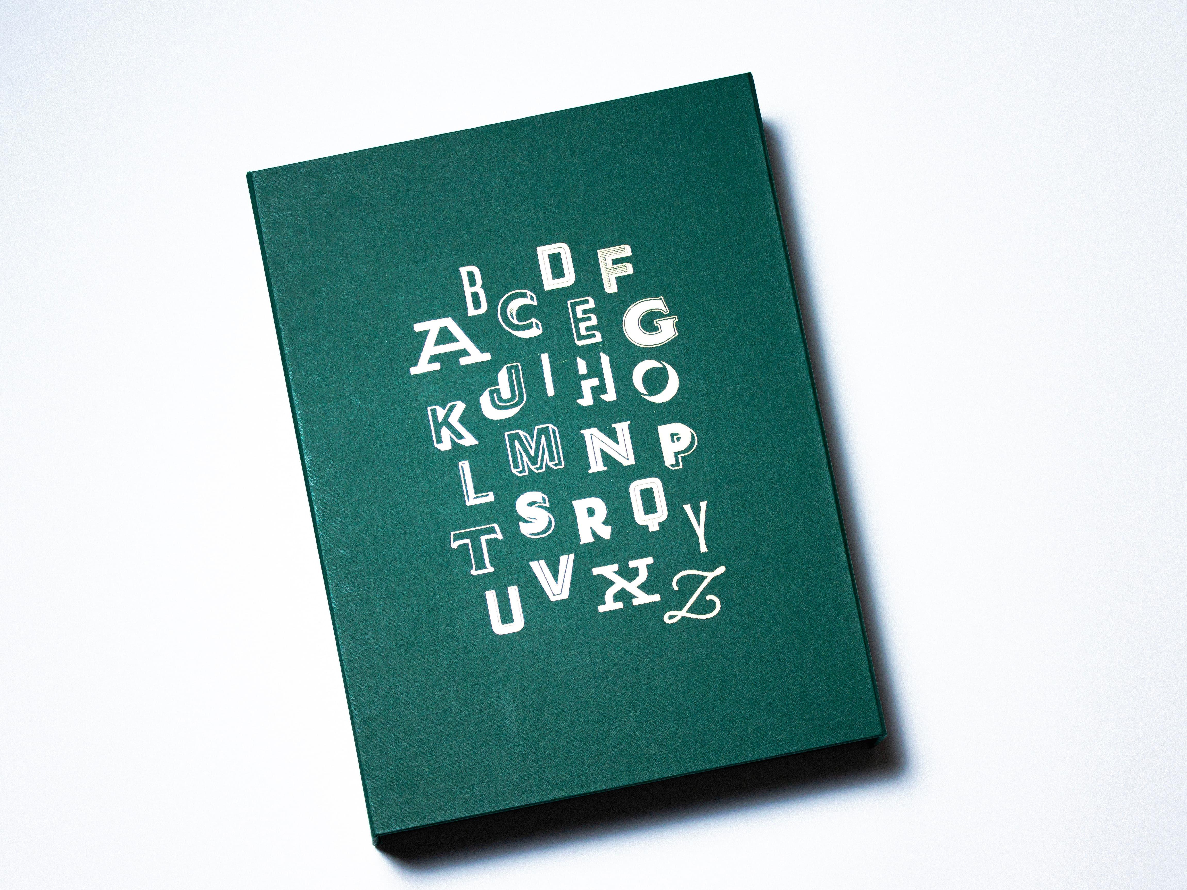 Dark green book with white ornamental letters on its cover.