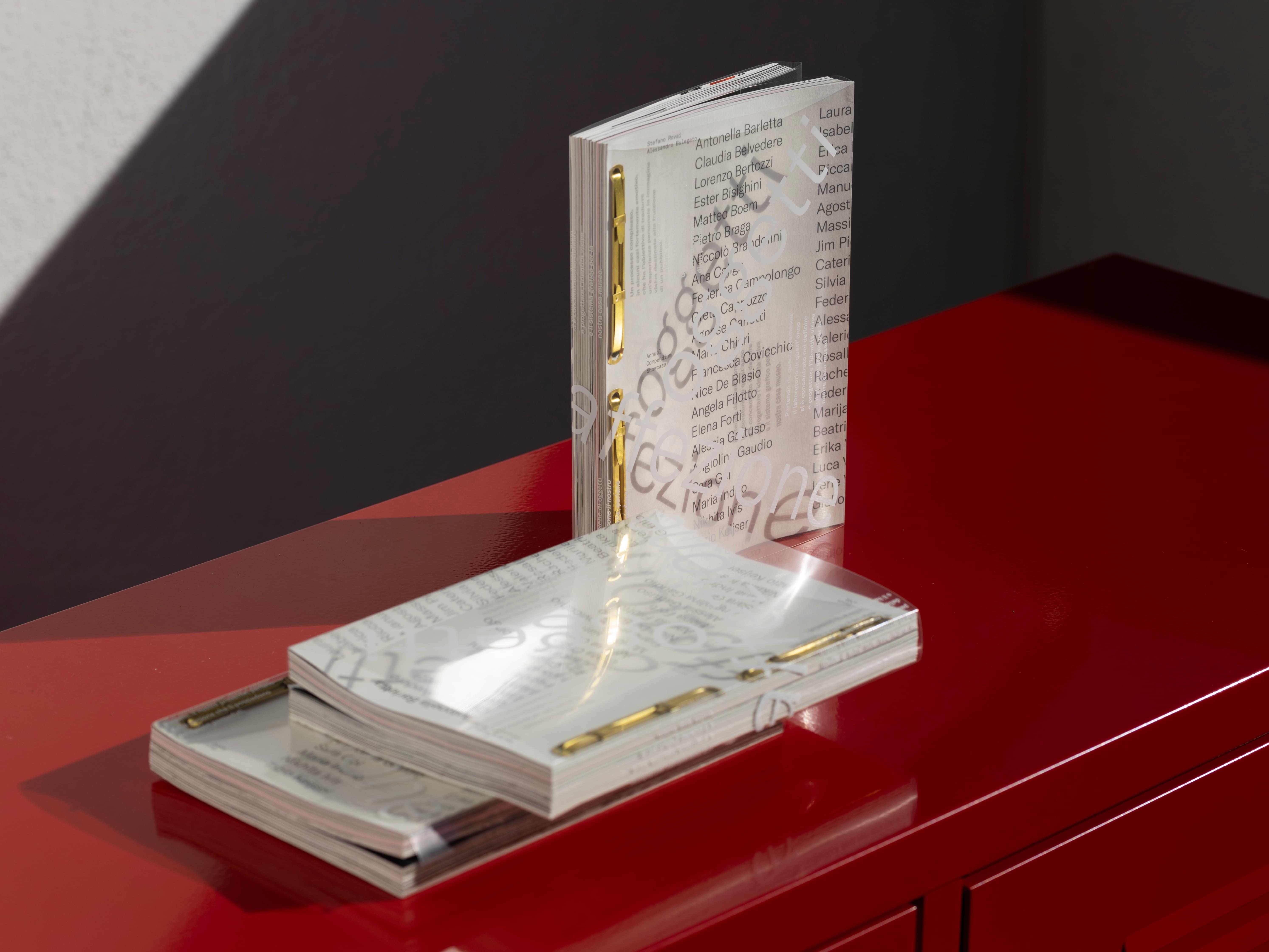 Clear stand holding printed papers on a red cabinet.