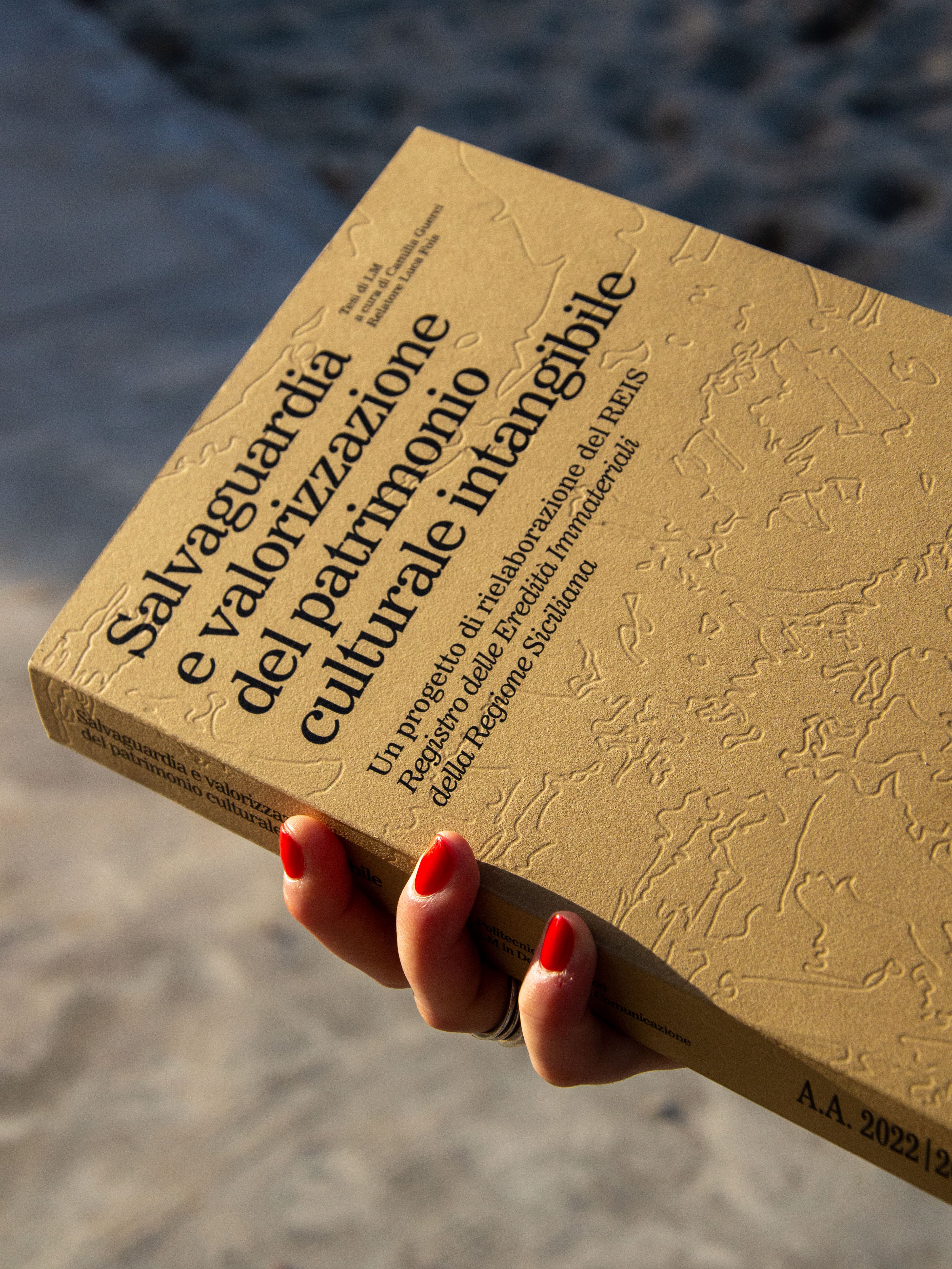 Golden-brown book with embossed patterns and large Italian lettering.