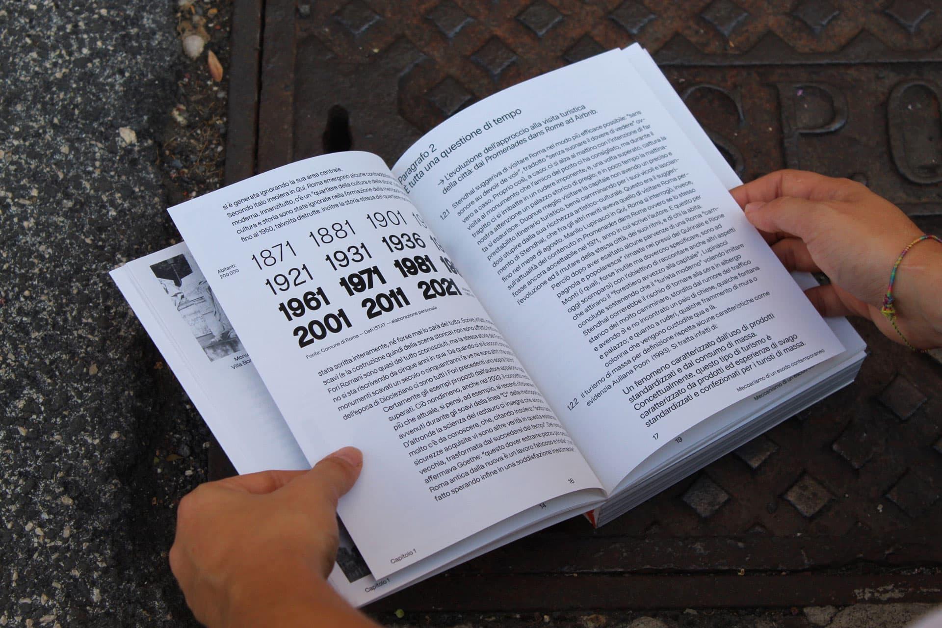 Open Stato in Luogo book showing a bold timeline and Italian text on a metal pavement.