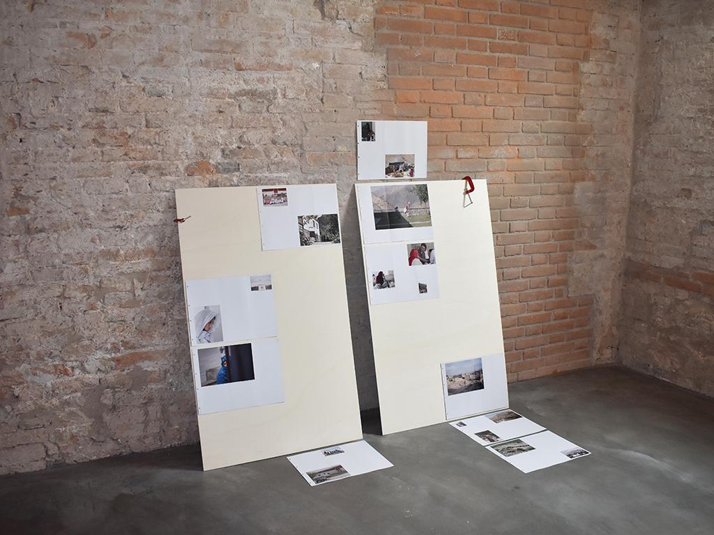 Brick by Brick exhibition installation with presentation boards and photographs arranged against a brick wall.