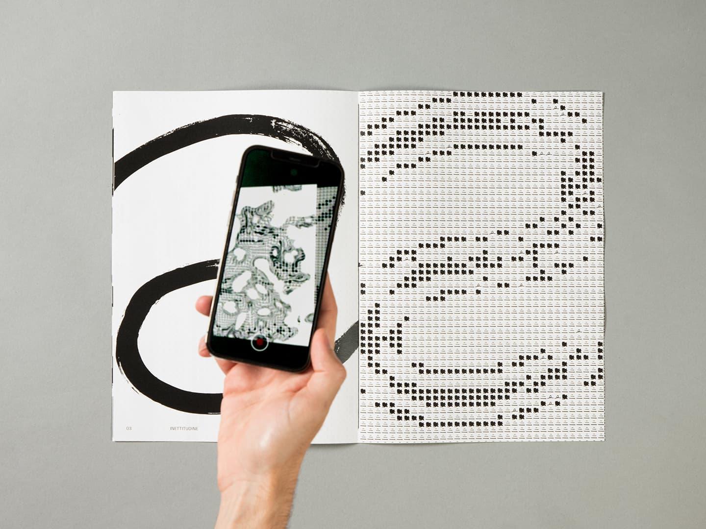 Hand holding a smartphone in front of black abstract graphics and a dot pattern.