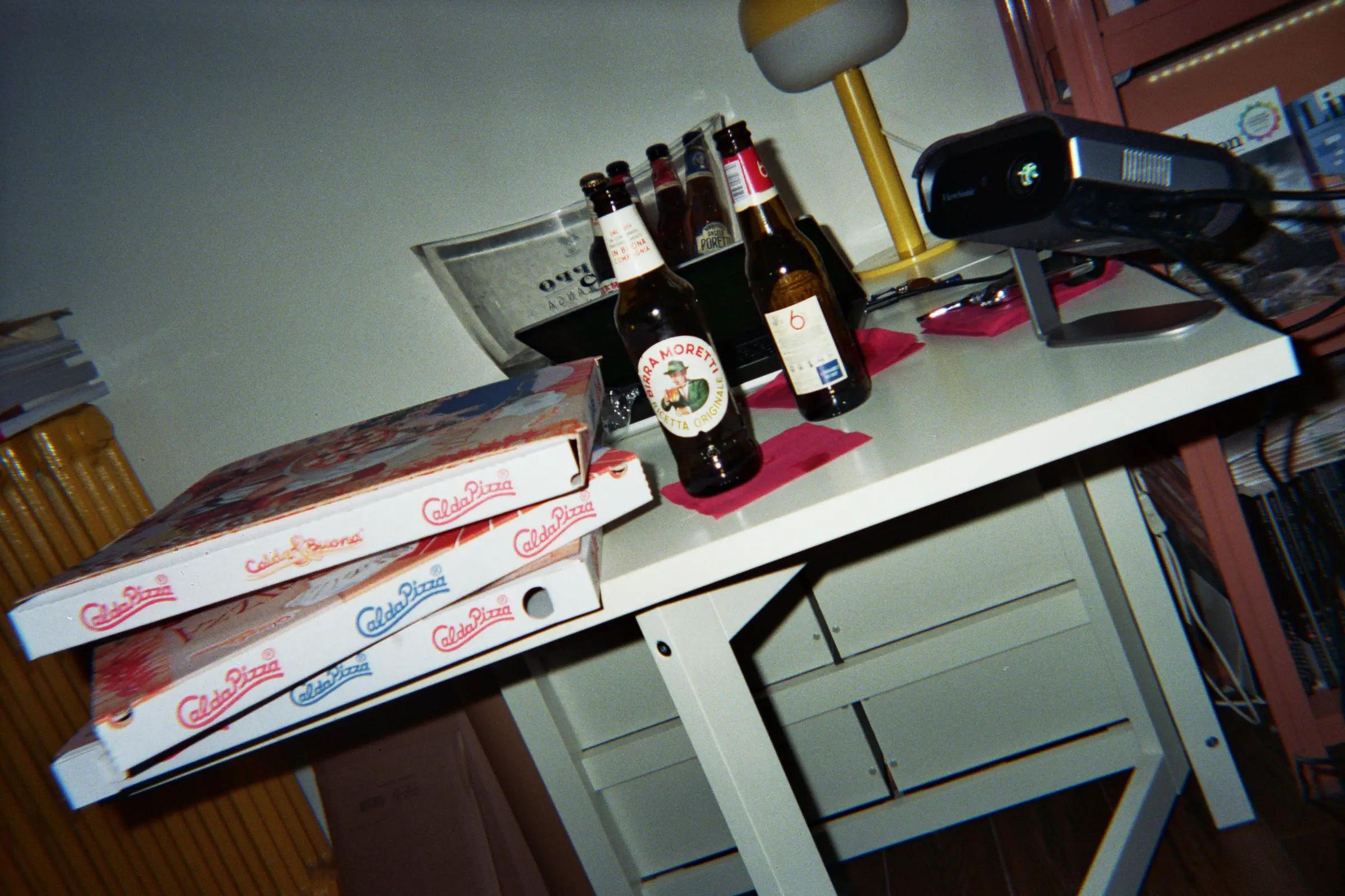 Pizza boxes, beer bottles and a projector on a white table at Frab's.