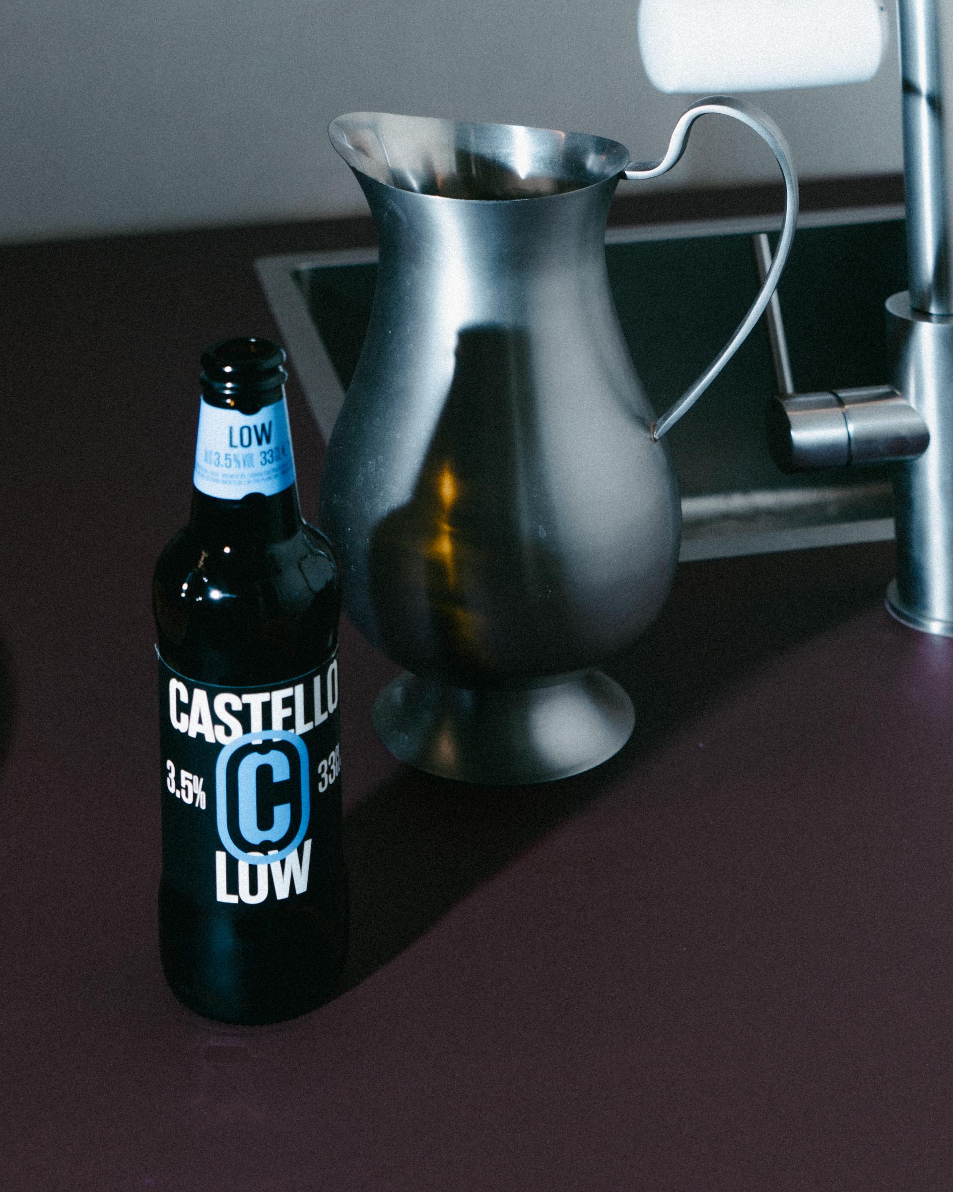 Castello Low beer bottle and a metal jug on the Studio Pesca kitchen counter.