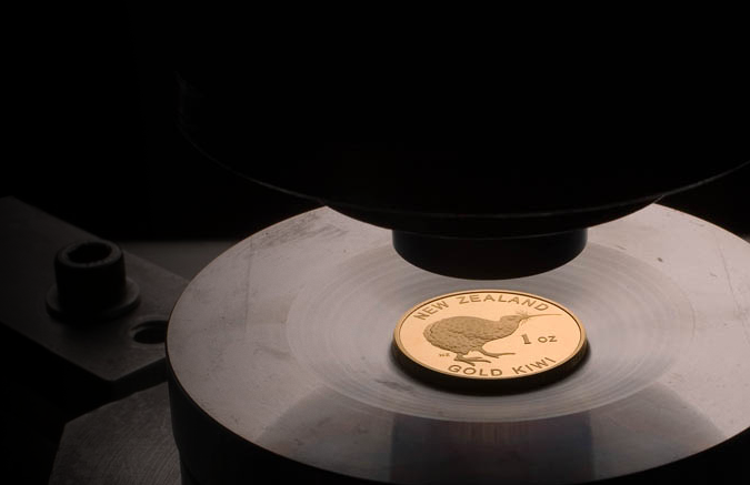 A gold 1oz coin with a "New Zealand Gold Kiwi" label