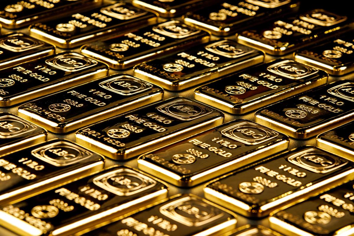 Stacks of shiny gold bars. The image conveys wealth and luxury under warm lighting.