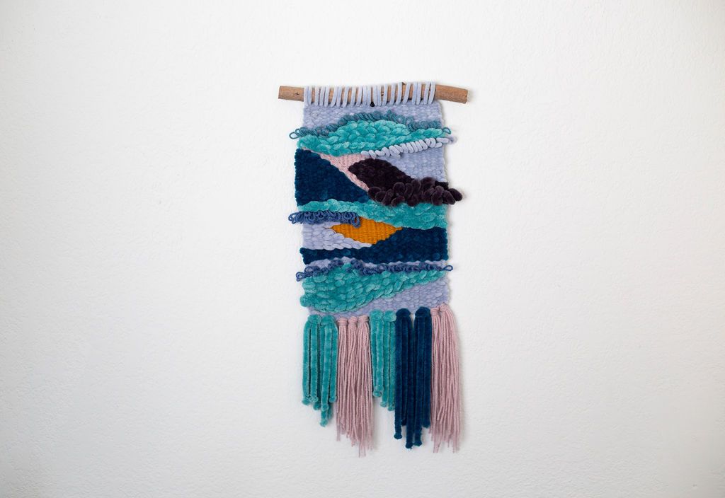 Woven wall hanging in layered teal, navy, lavender and mustard with long fringe