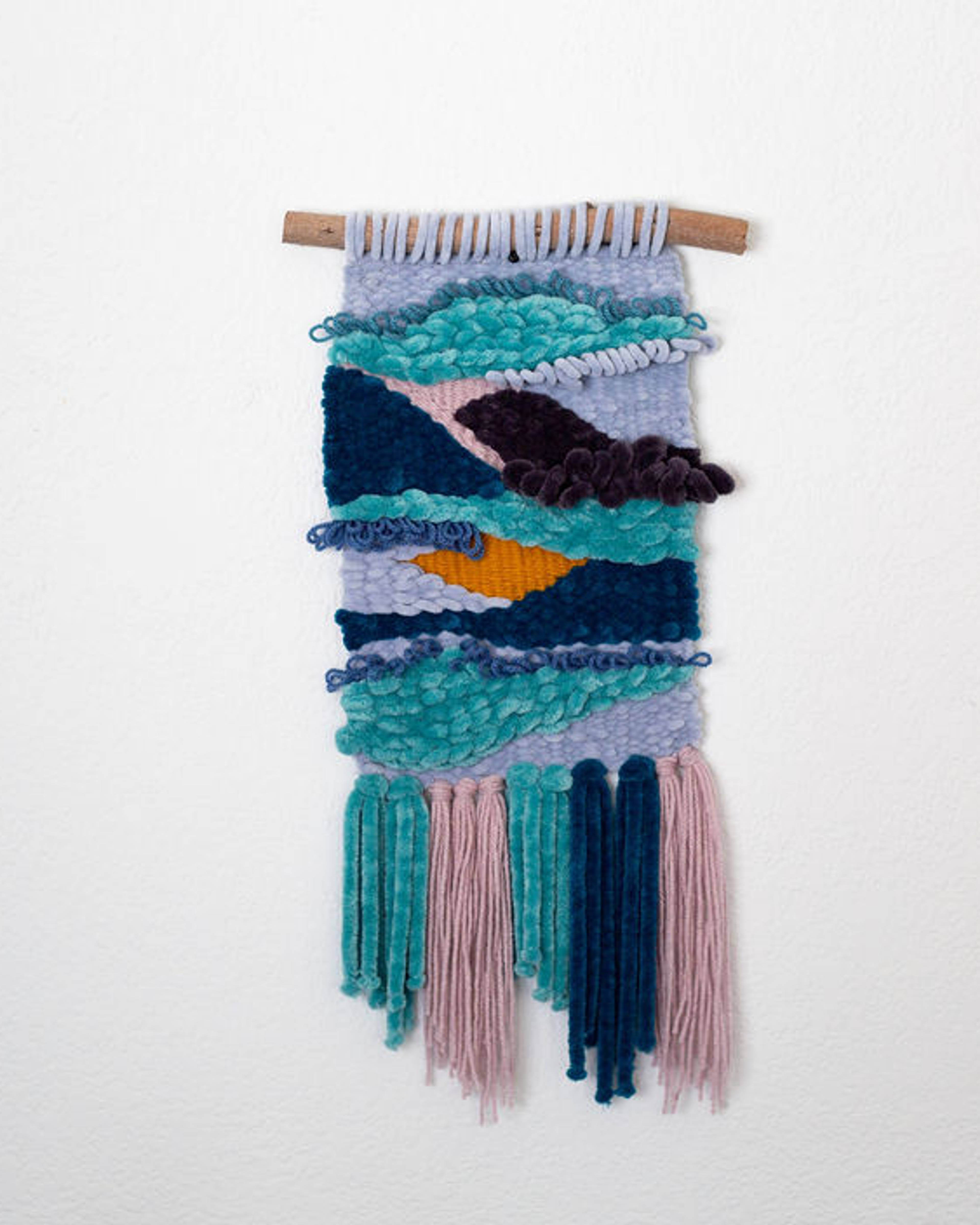 Woven wall hanging in layered teal, navy, lavender and mustard with long fringe