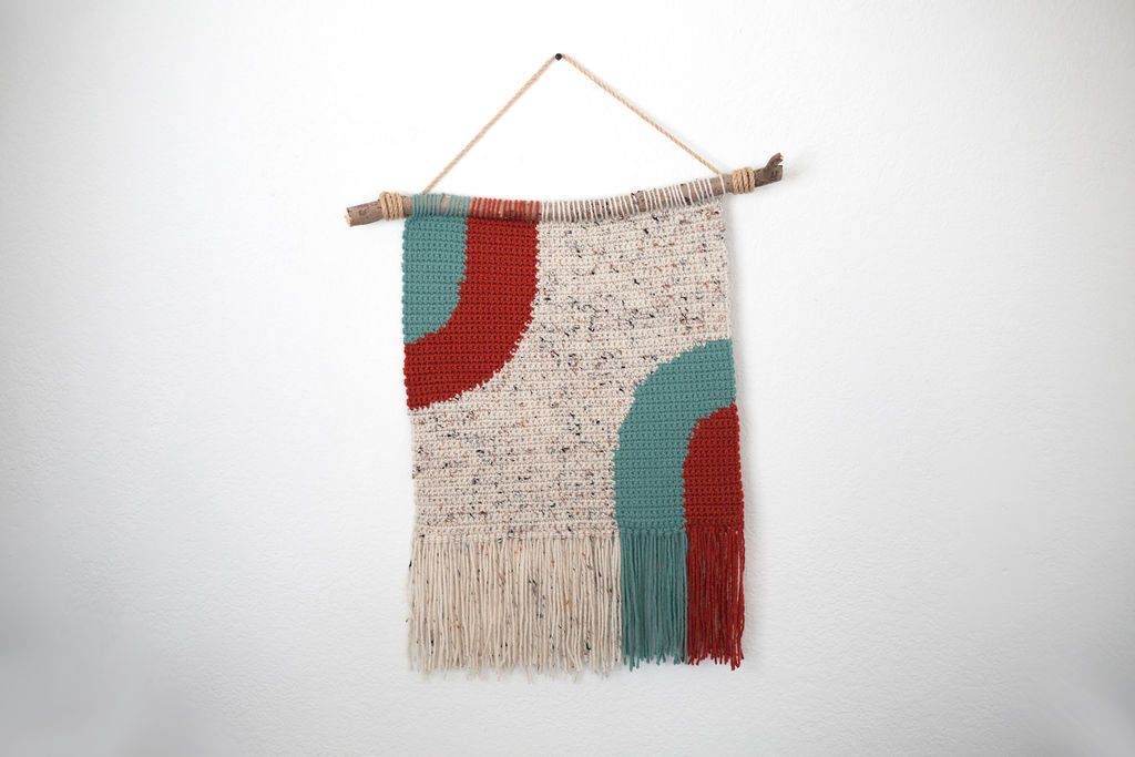 Speckled cream crochet tapestry with teal and red arches