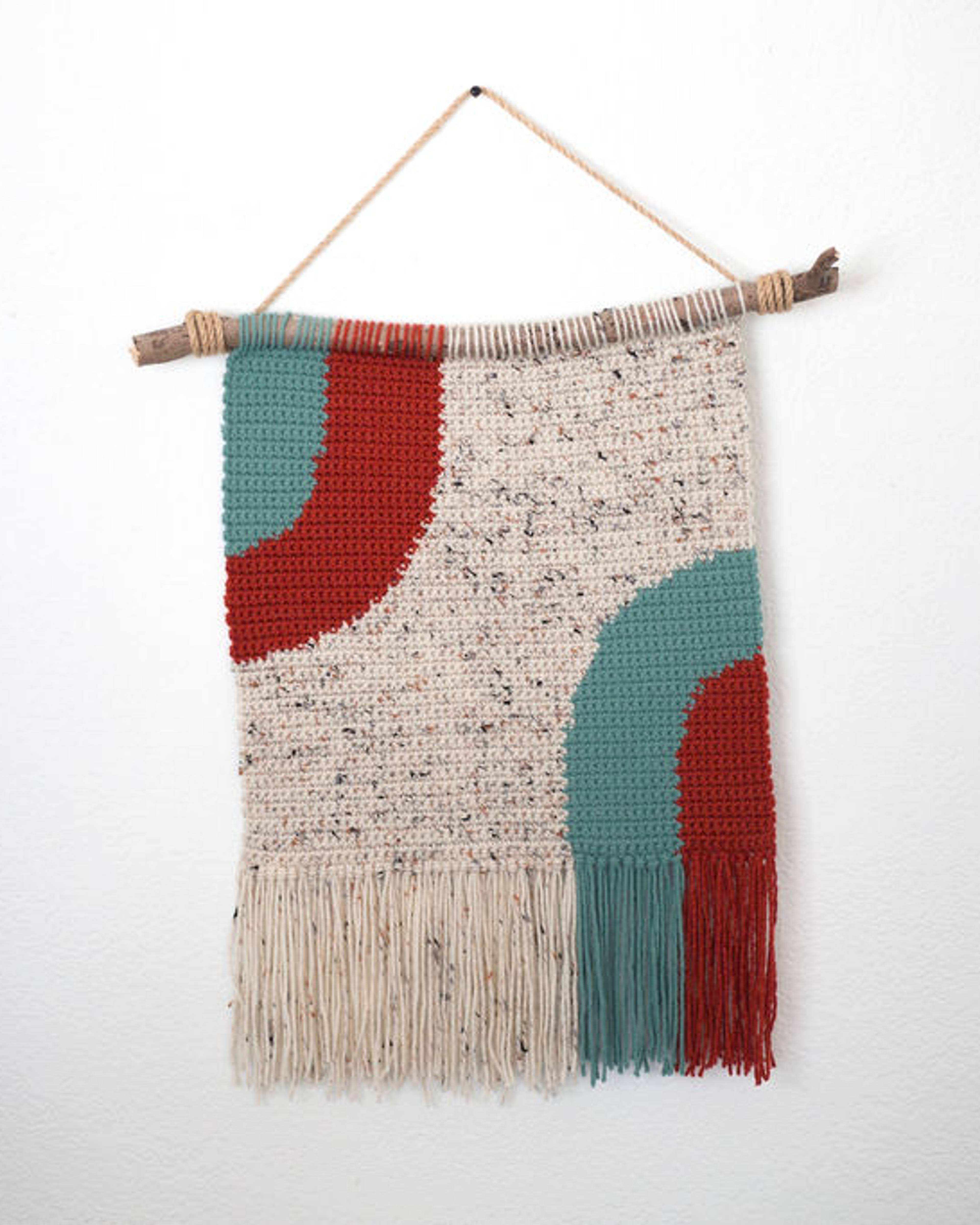 Speckled cream crochet tapestry with teal and red arches