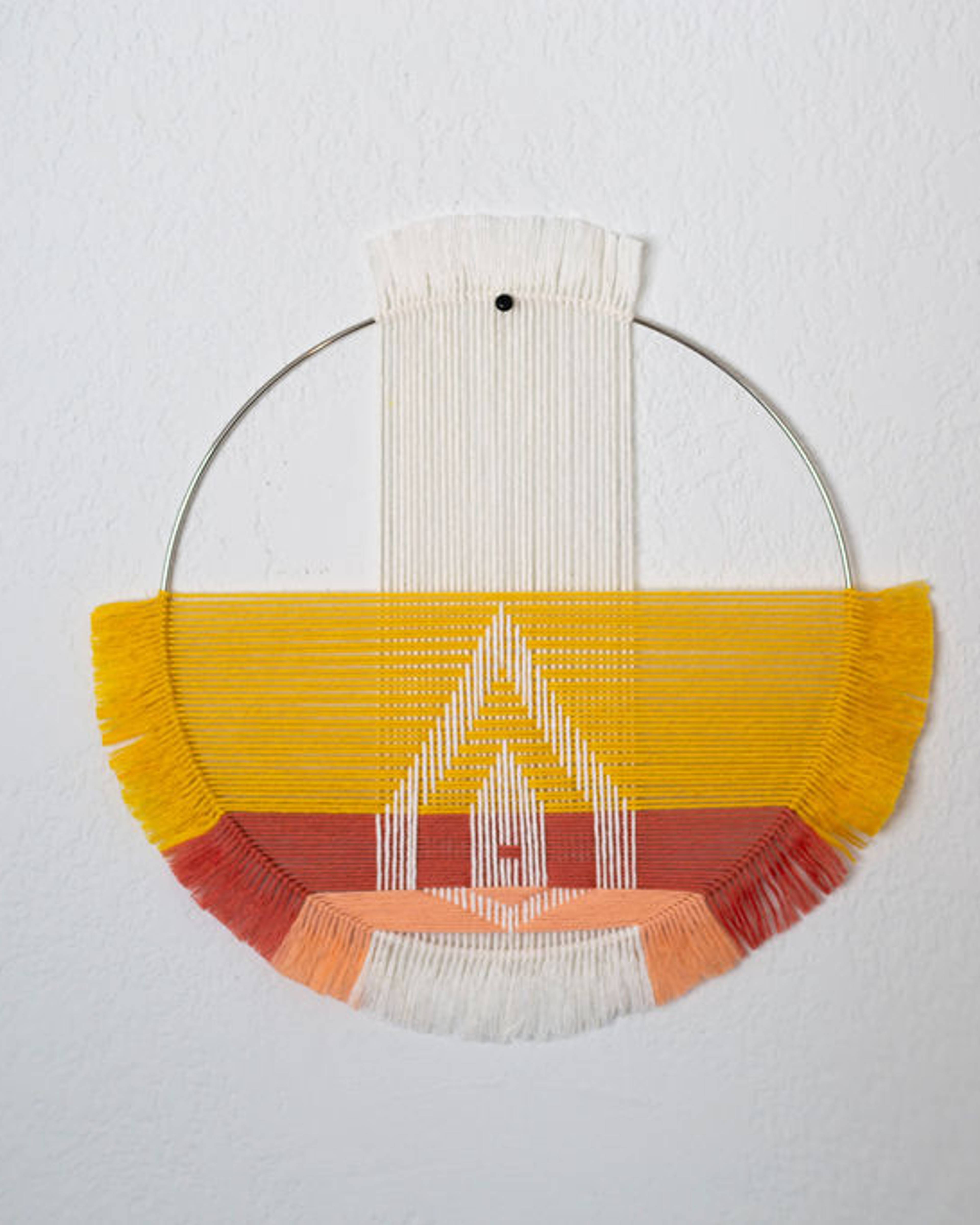 Half-moon weaving on a brass hoop in yellow, coral and white with a geometric motif