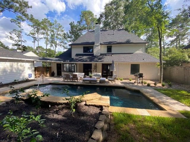 Backyard view of a Conroe home and swimming pool after gutter and downspout installation