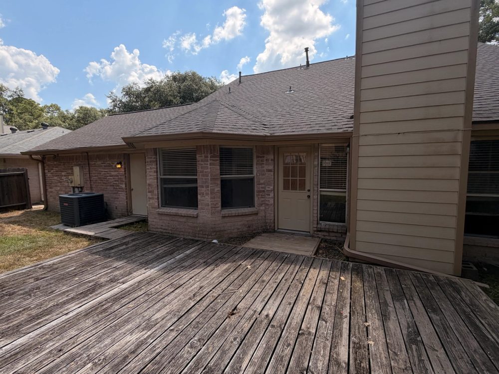 Buckskin brown 6-inch seamless aluminum gutters running along the rear roofline of a Spring brick home