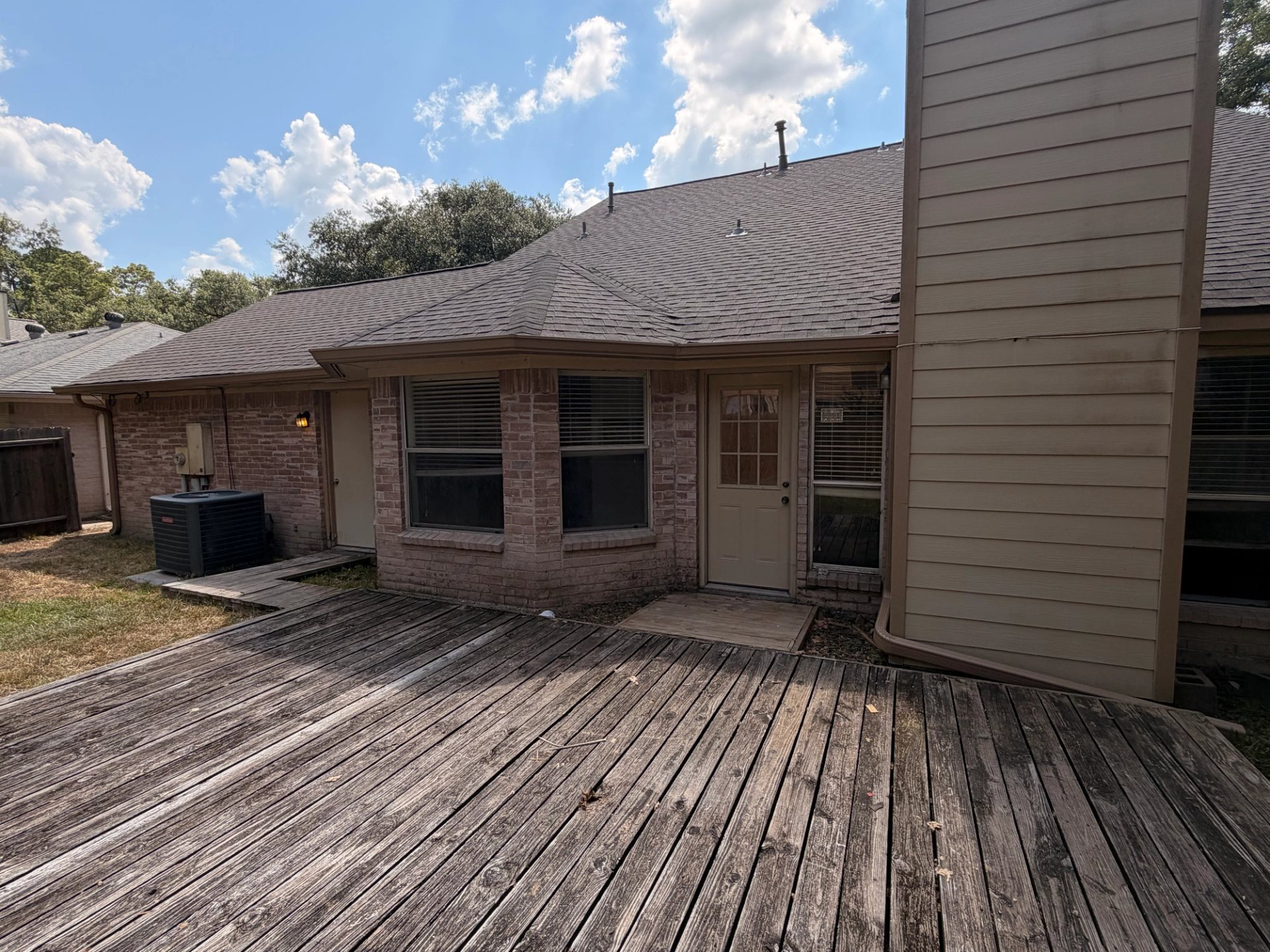 Buckskin brown 6-inch seamless aluminum gutters running along the rear roofline of a Spring brick home