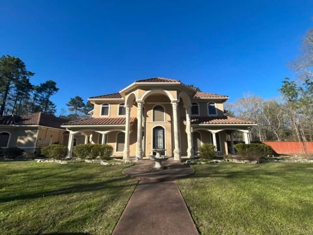 Light cream seamless gutters across the full front elevation of a Mediterranean-style stucco home