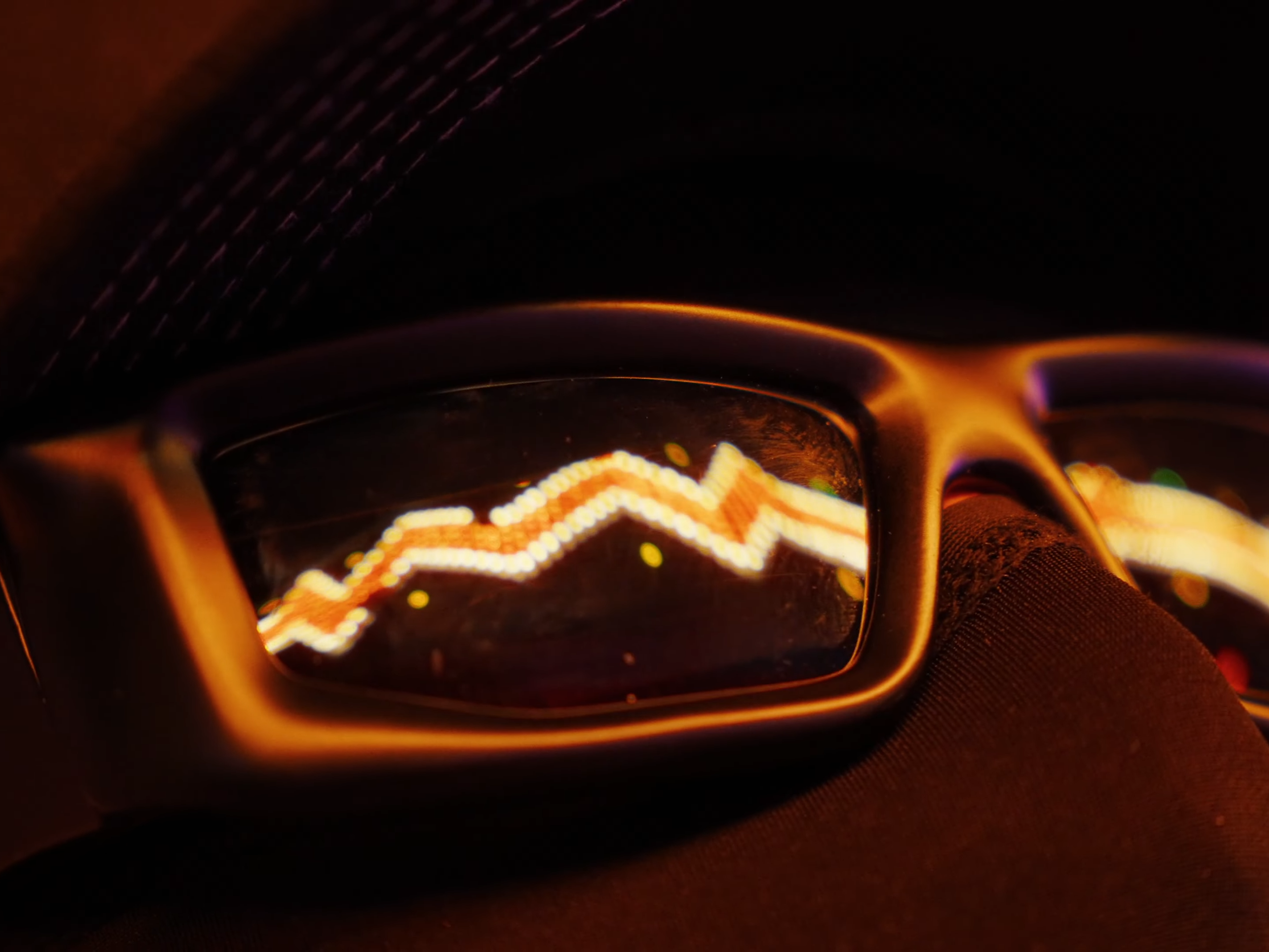 plan rapproché serré de l'artiste sur ces lunettes avec des reflets de néons