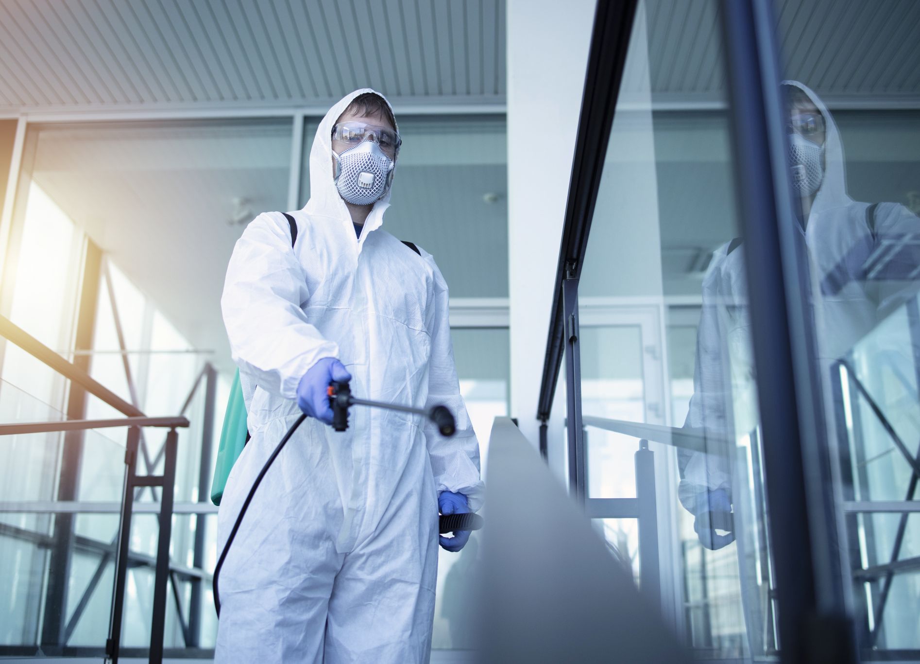 Man i skyddskläder som sanerar