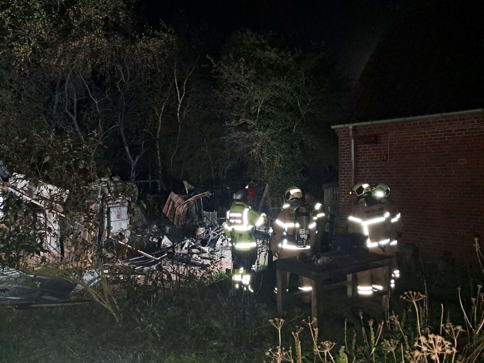 technicians working at a fire-damaged site during nighttime restoration operations