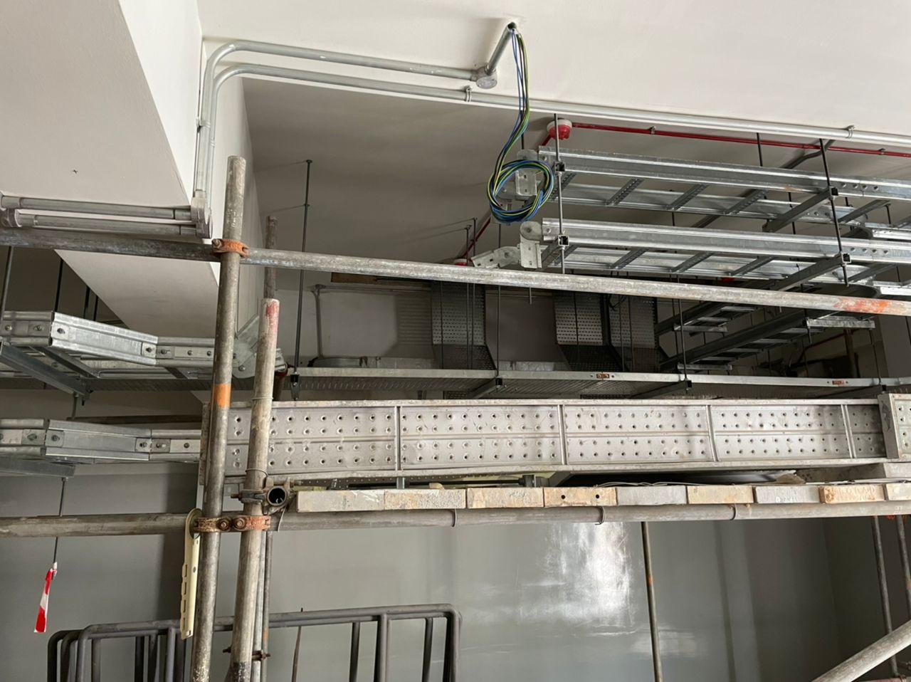Perforated cable tray and cable ladder on hangers near a wall