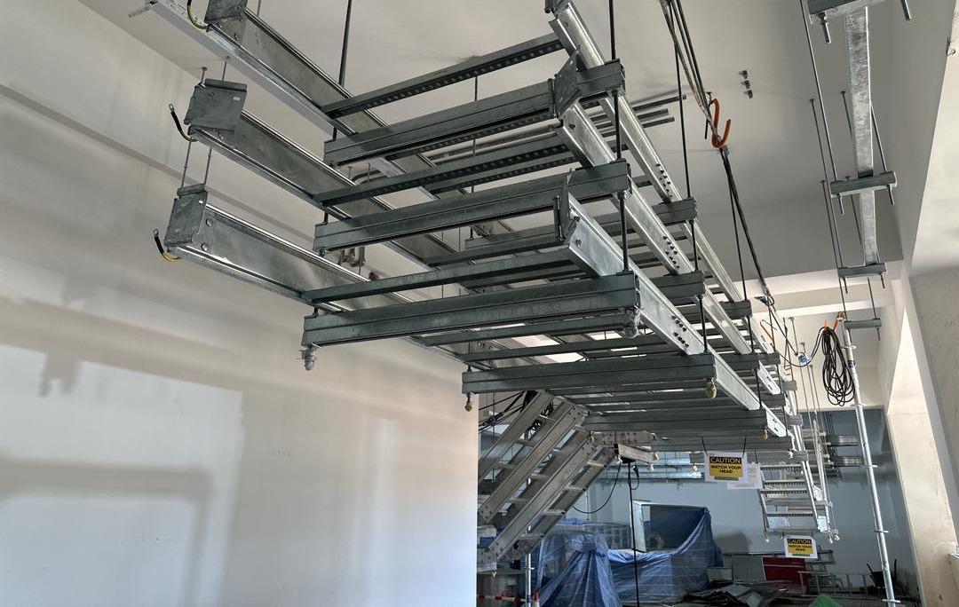 Tiered cable ladder on trapeze hangers seen from below