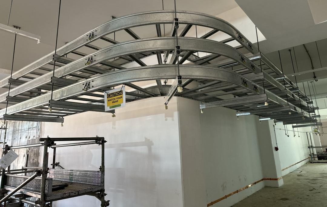Three tiers of cable ladder turning around a column on horizontal bends