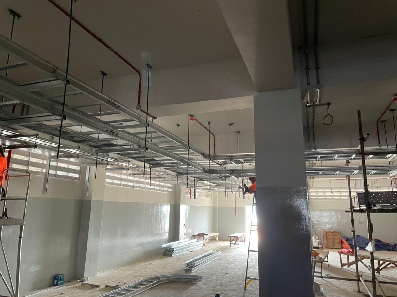 Parallel cable ladder and tray runs along a wall beside a column
