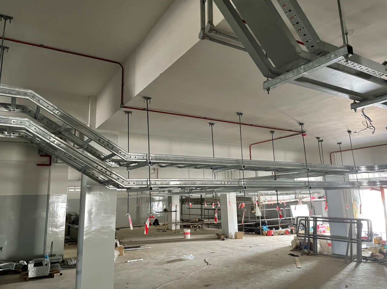 Cable ladder runs suspended from the ceiling across an open substation floor