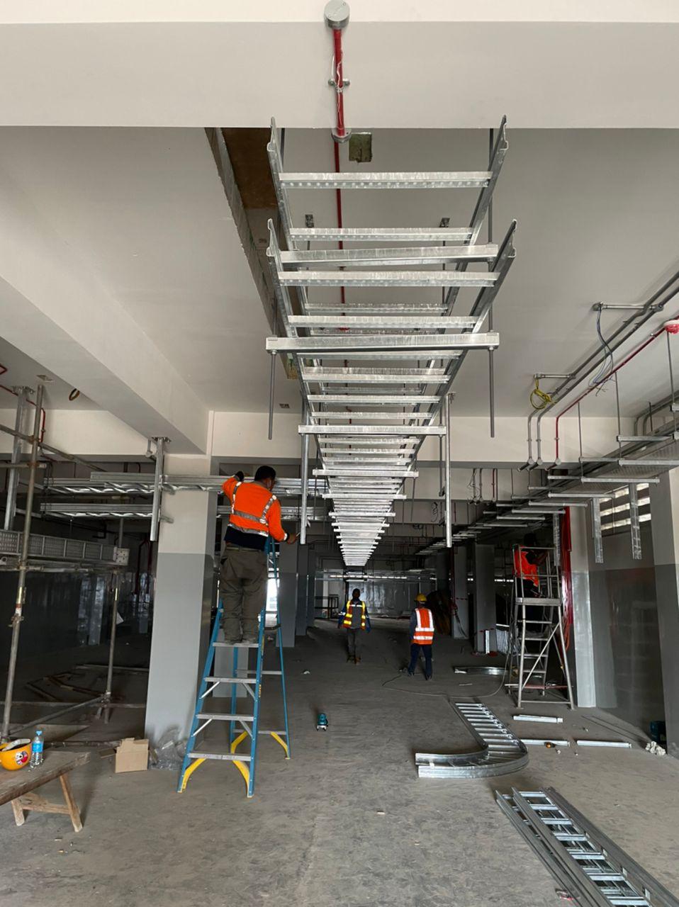 Long straight cable ladder run along a corridor ceiling