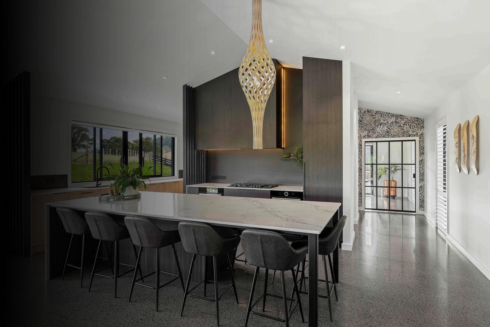 Kitchen and living area with table and chairs in the foreground and a glass and aluminium cavity slider to the right