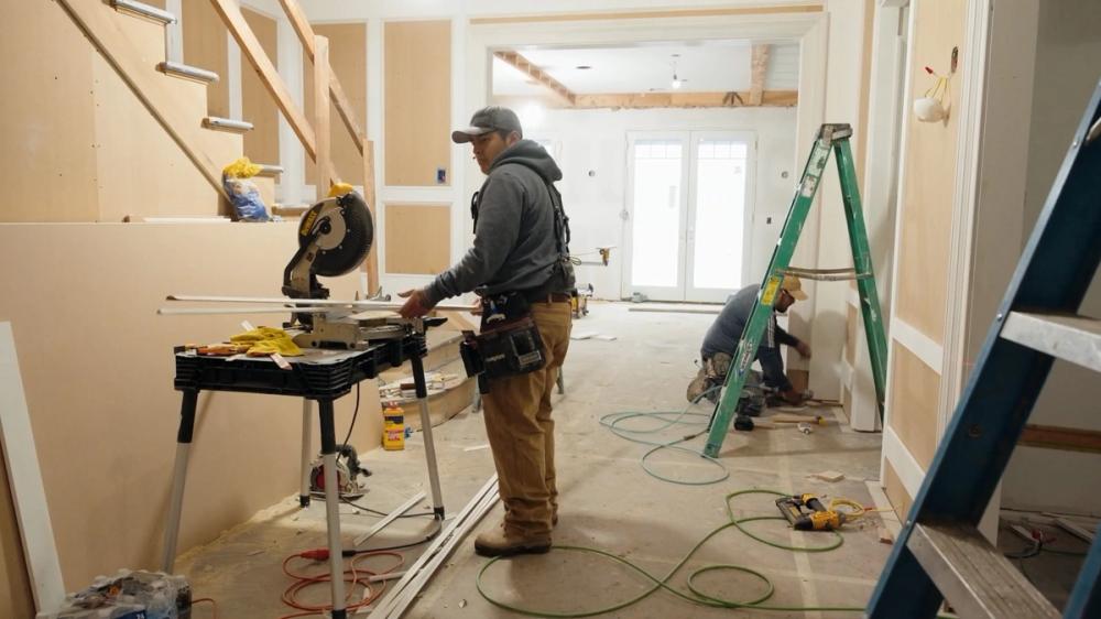 Builders working on trim and finishing details Builders working on trim and finishing details