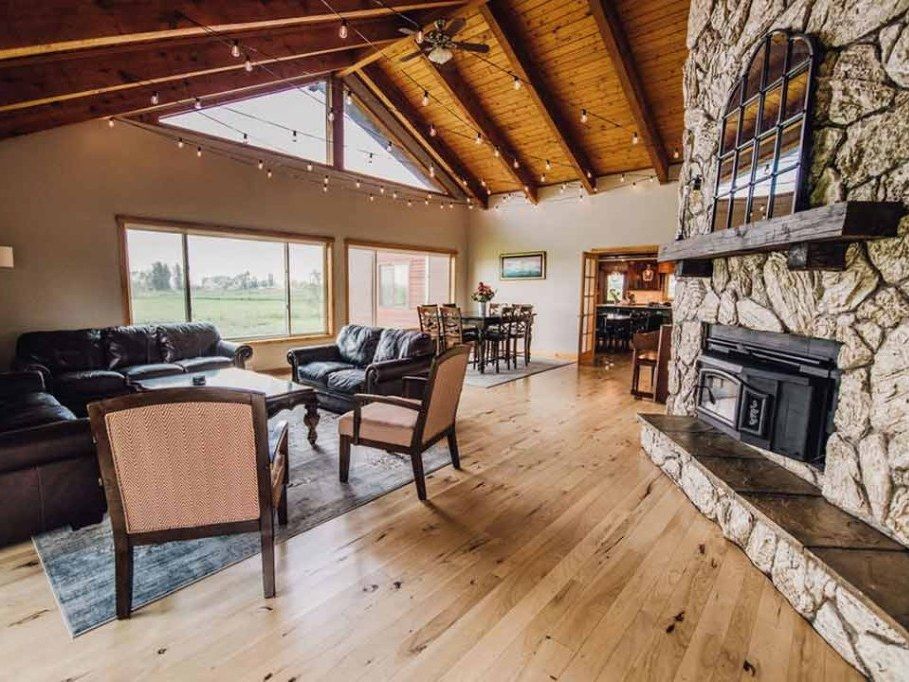 Lodge great room with the stone fireplace, wood stove, and string lights
