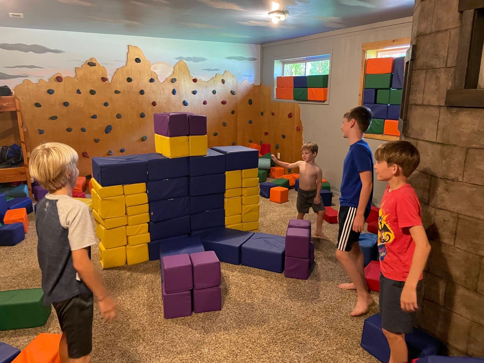 Kids around a foam-block fort in the bunk playroom