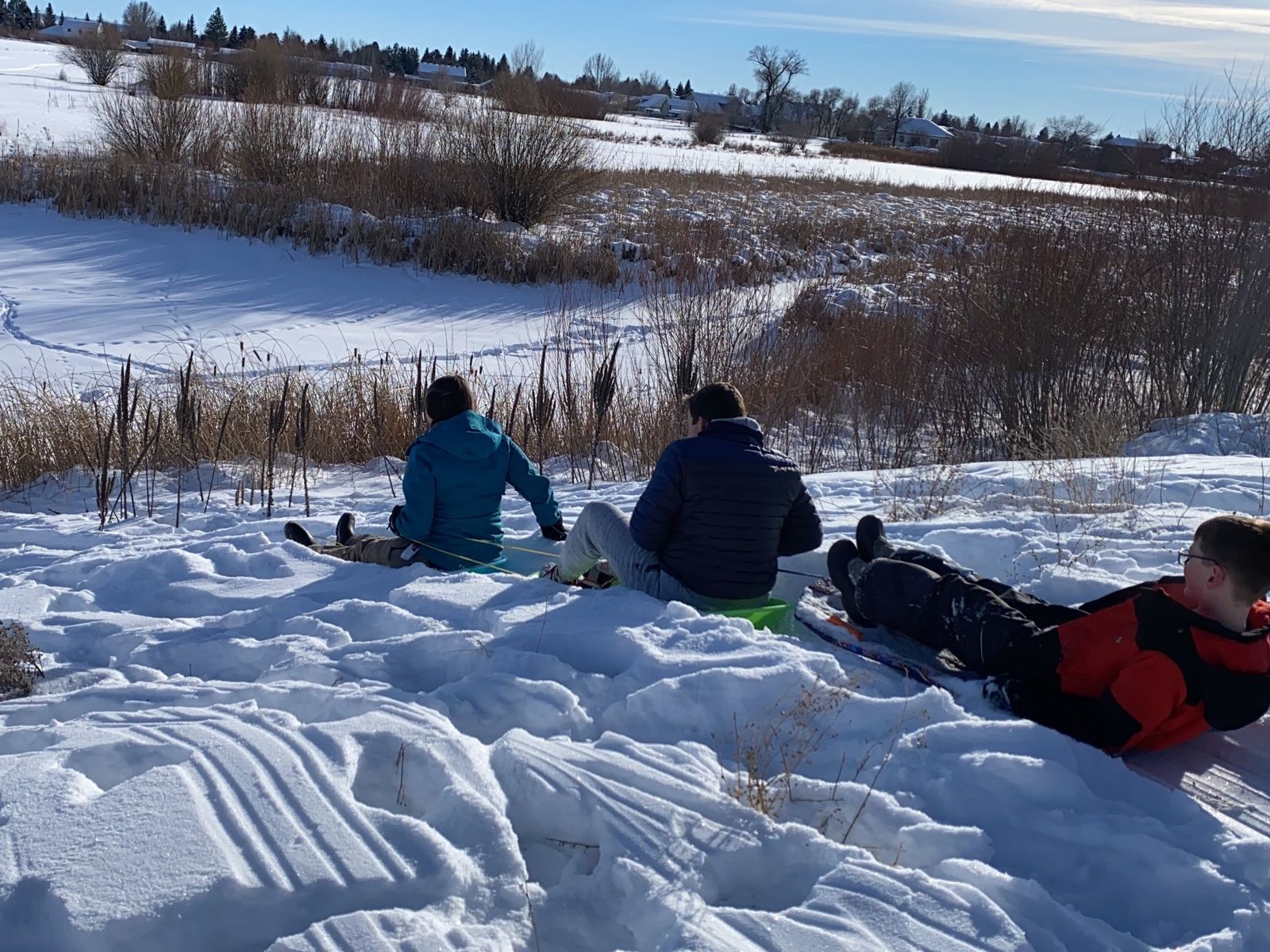 Looking down the sledding hill toward the frozen pond on this lodge yard