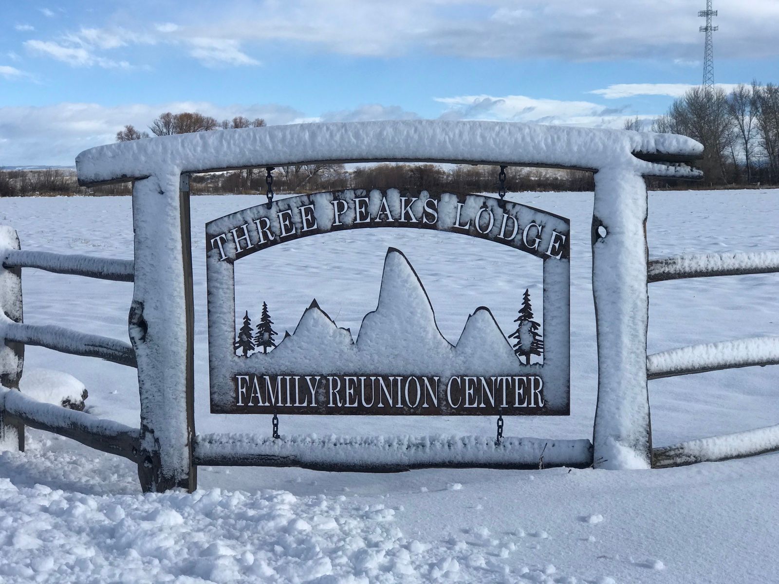 Three Peaks Lodge entrance sign in snow