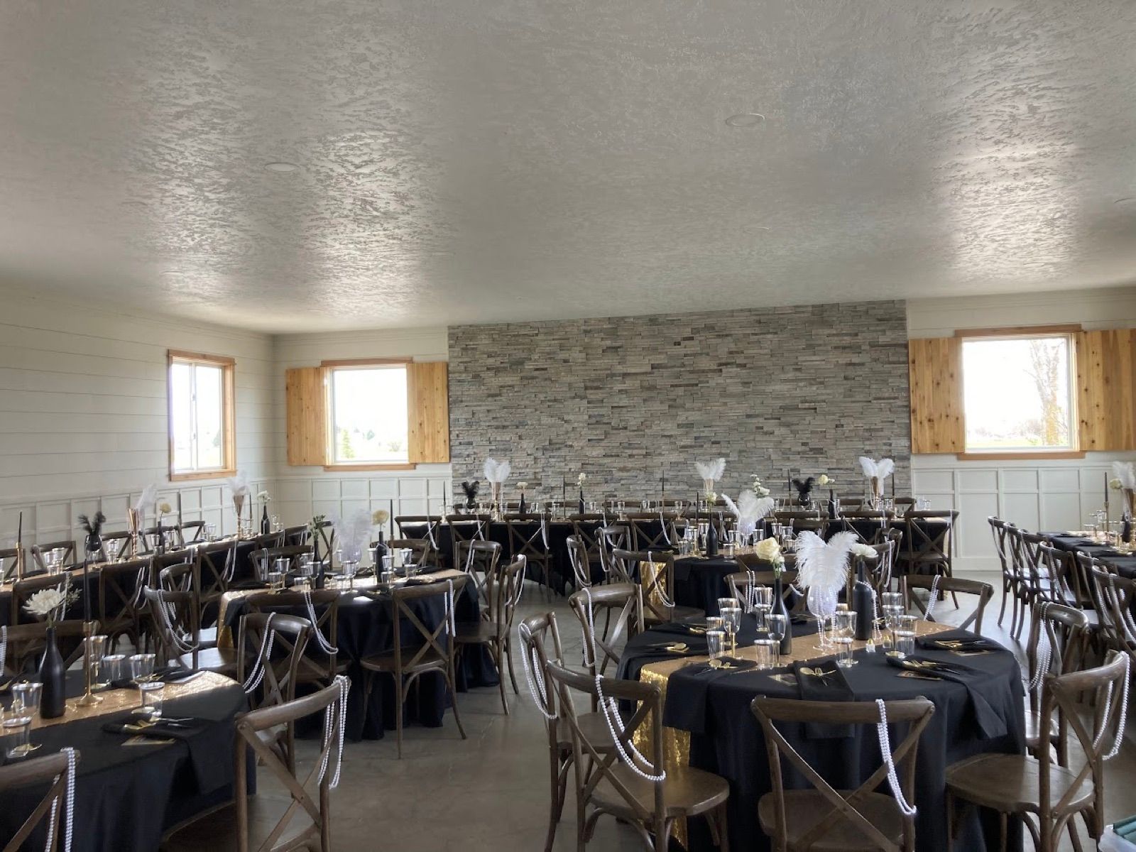 Indoor reception with black and gold tables and feather centerpieces
