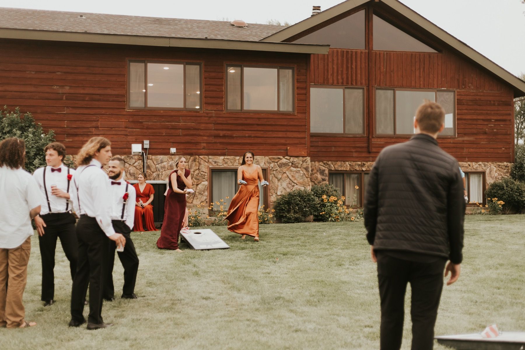 Wedding party playing cornhole on the lodge lawn