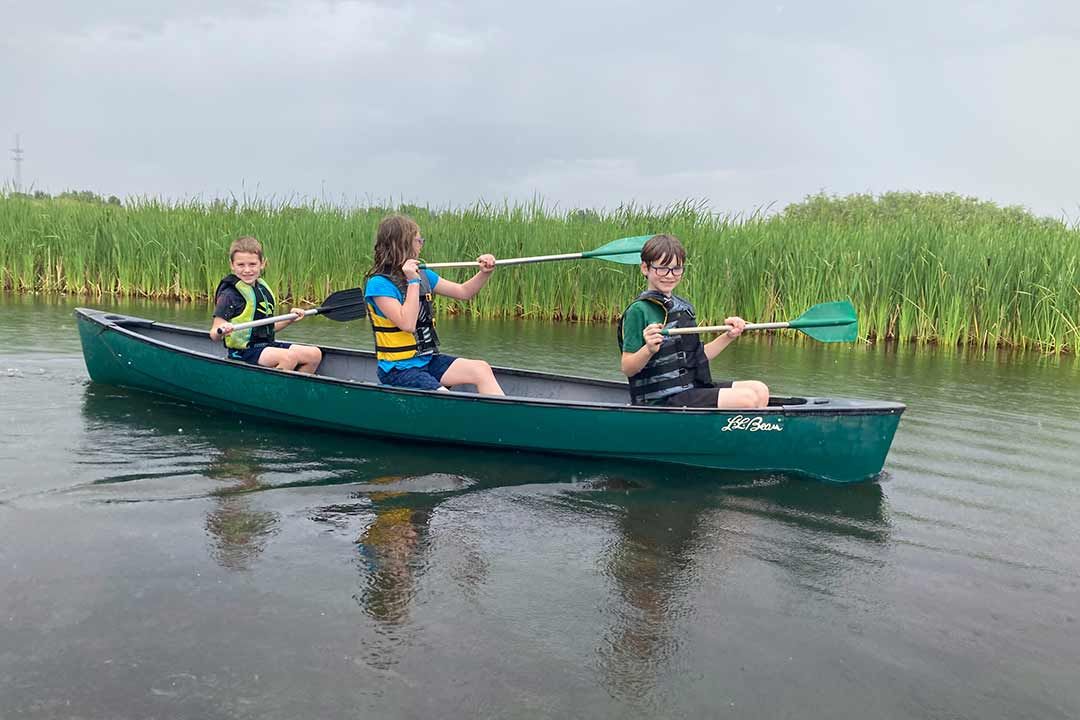 Kids canoeing on the lodge pond