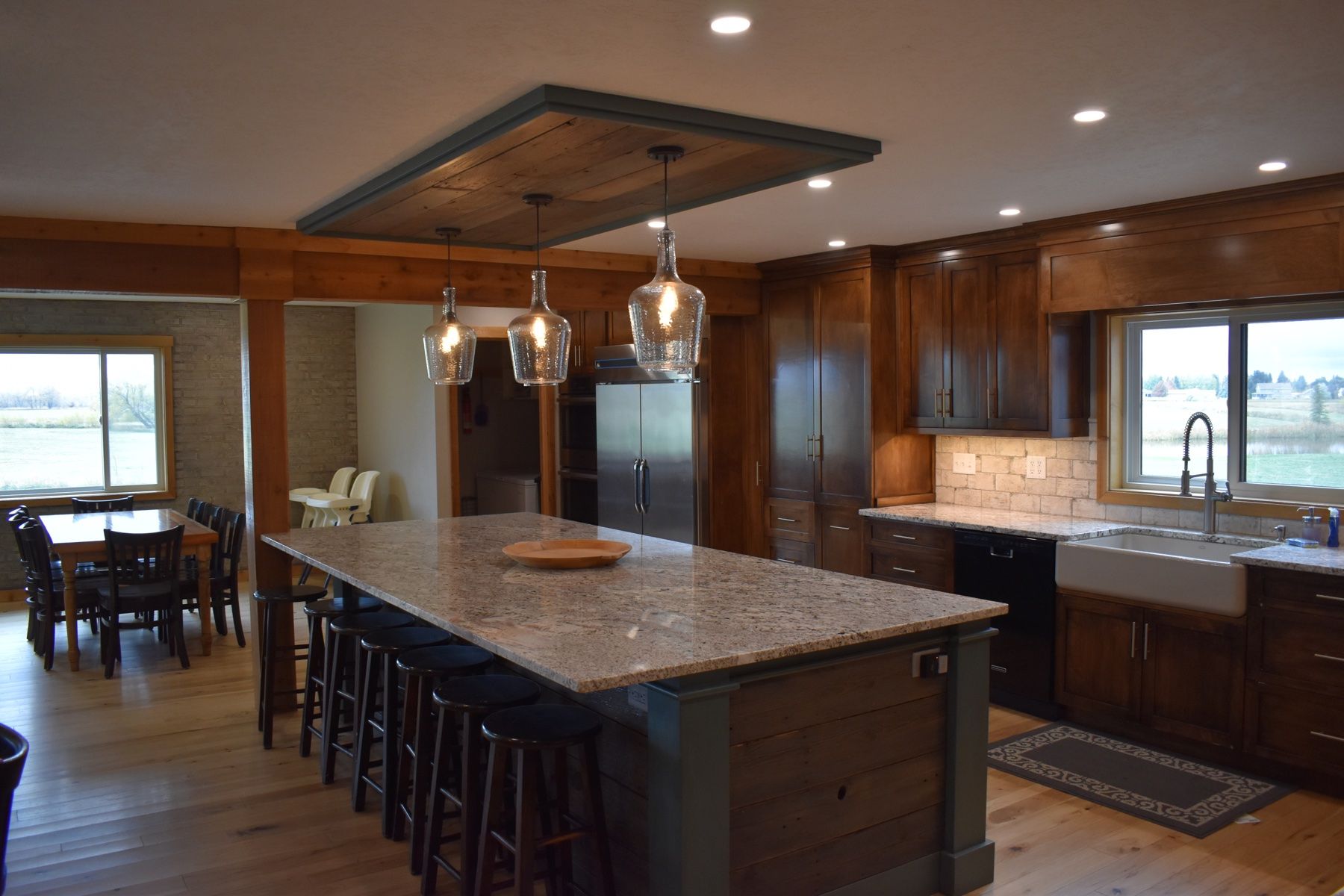 Commercial kitchen island with bar stools opening to the dining hall