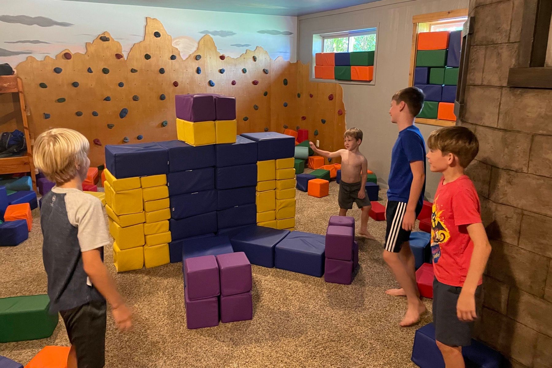 Kids in the bunk playroom with the climbing wall