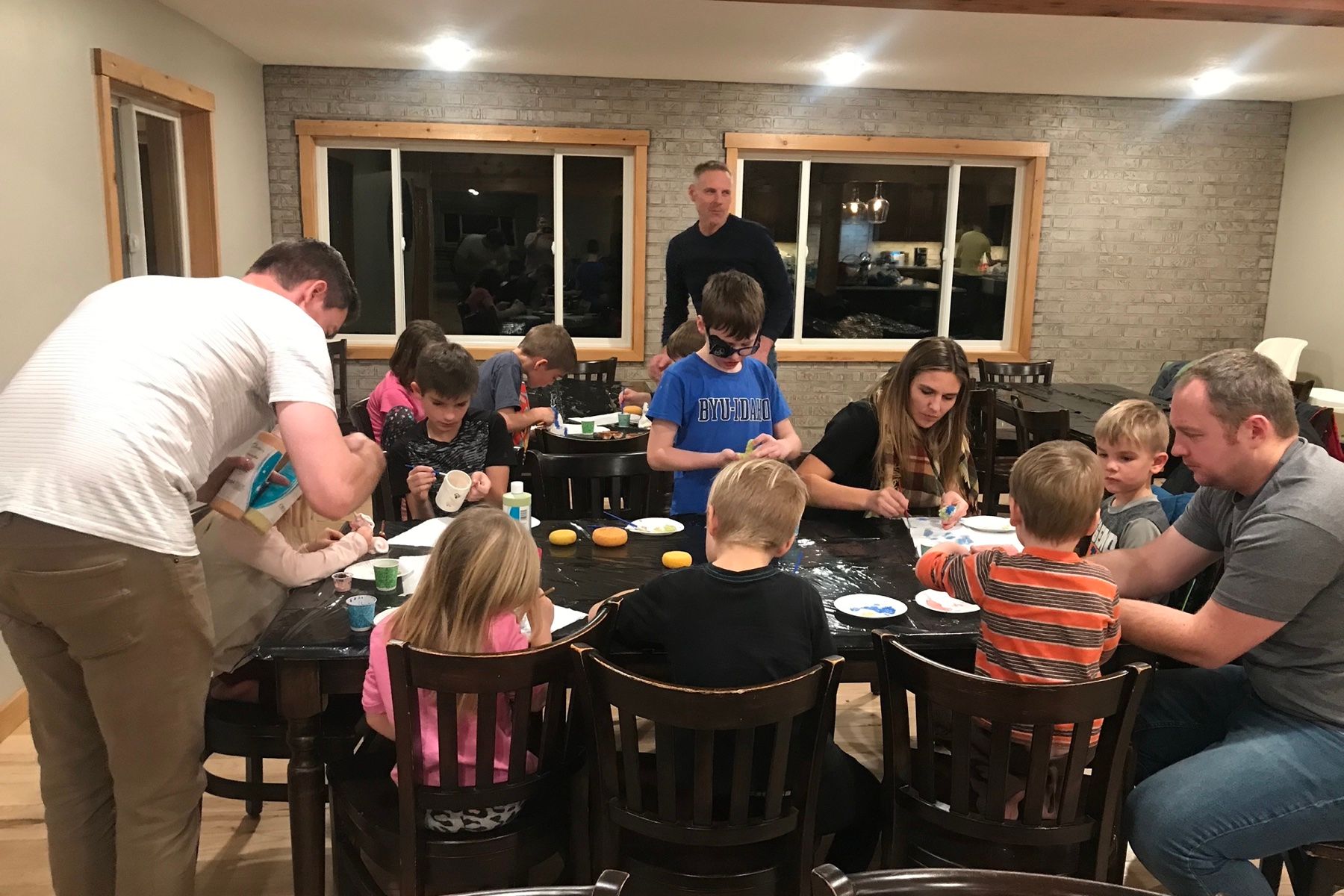 Adults and kids painting ceramics at the lodge dining tables