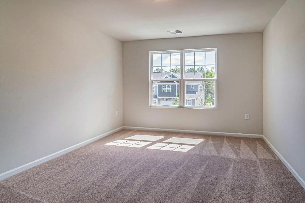 Beige wall-to-wall carpet in a bright empty room after cleaning