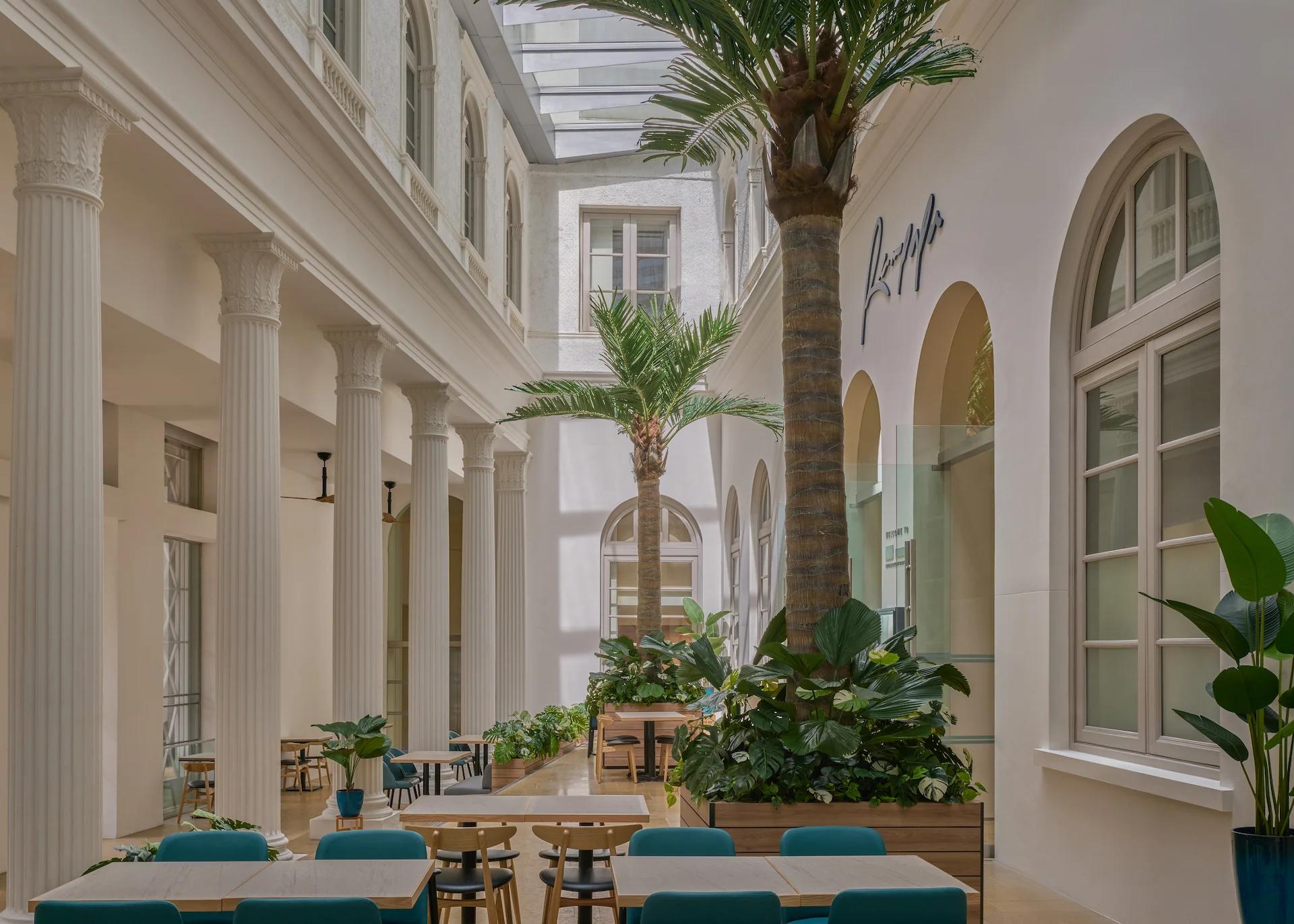 Rempapa restaurant signage on white arched facade with tall ionic columns and tropical courtyard dining, National Gallery Singapore by LAANK