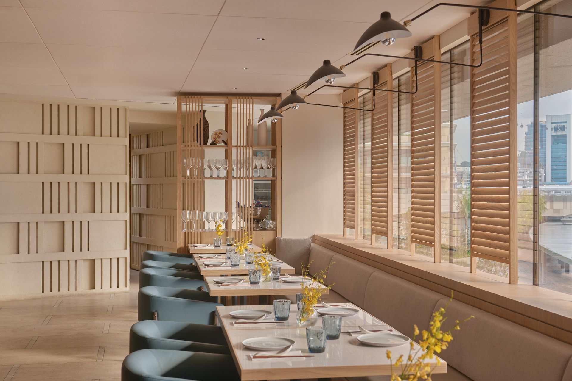 Contemporary restaurant interior with timber batten screen dividers, banquette seating and teal upholstered chairs, Chatterbox Cafe at Resorts World Sentosa Singapore by LAANK